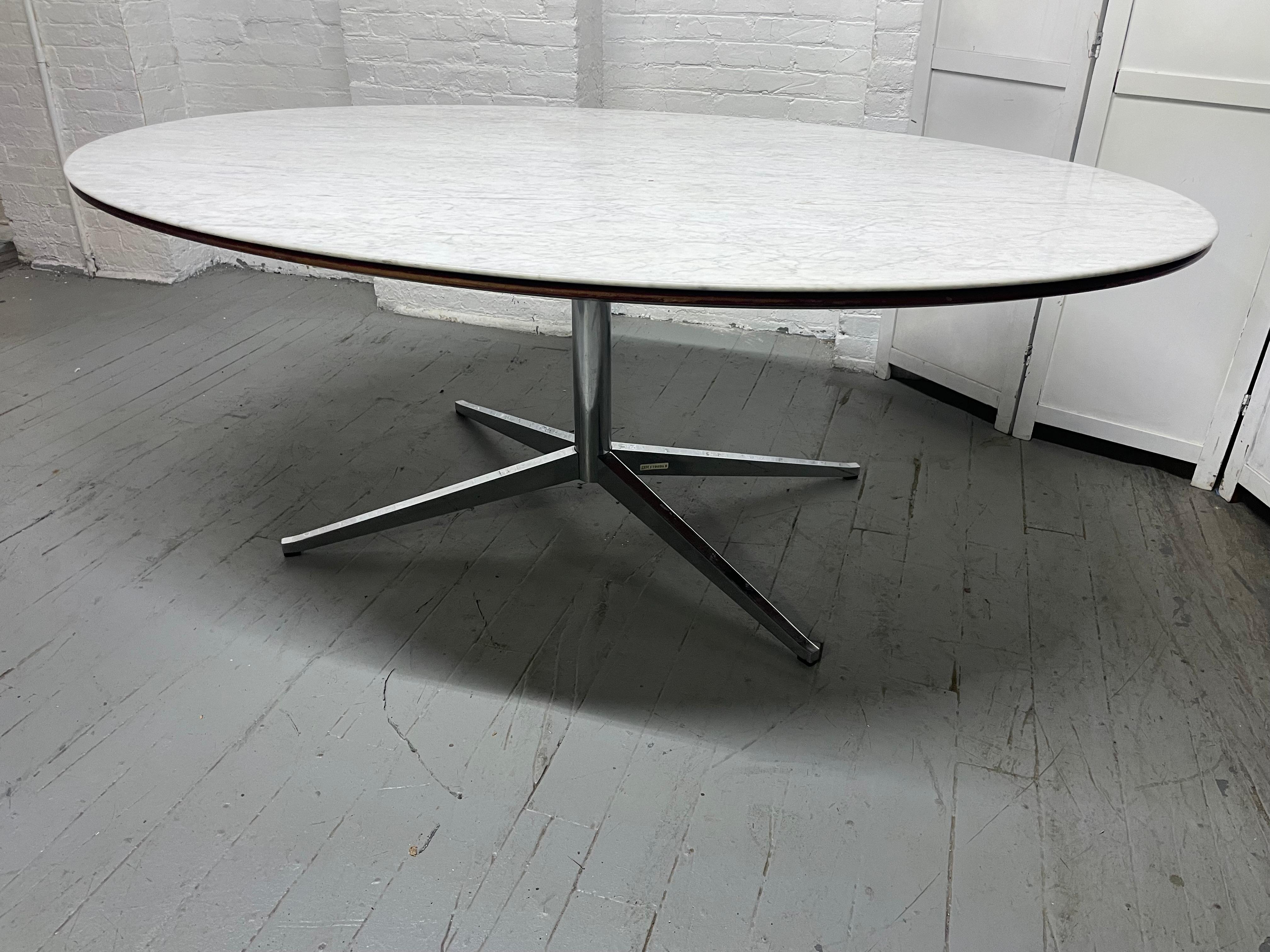 Table de salle à manger Florence Knoll des années 1960 avec un plateau en marbre de forme ovale.  Le marbre est soutenu par un plateau ovale en bois sur une base solide en acier chromé avec 4 pieds évasés. Peut également être utilisée comme table de