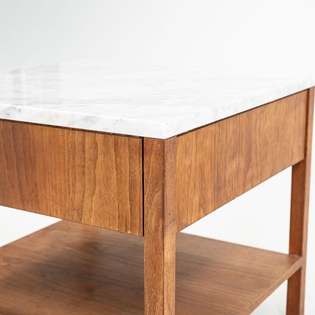 This is a walnut bedside table, Model 327 IS, designed by Florence Knoll in 1956. This particular example dates to the 1960s and has a white marble top. The design features a walnut case with one drawer above a lower shelf.
 
 The table measures