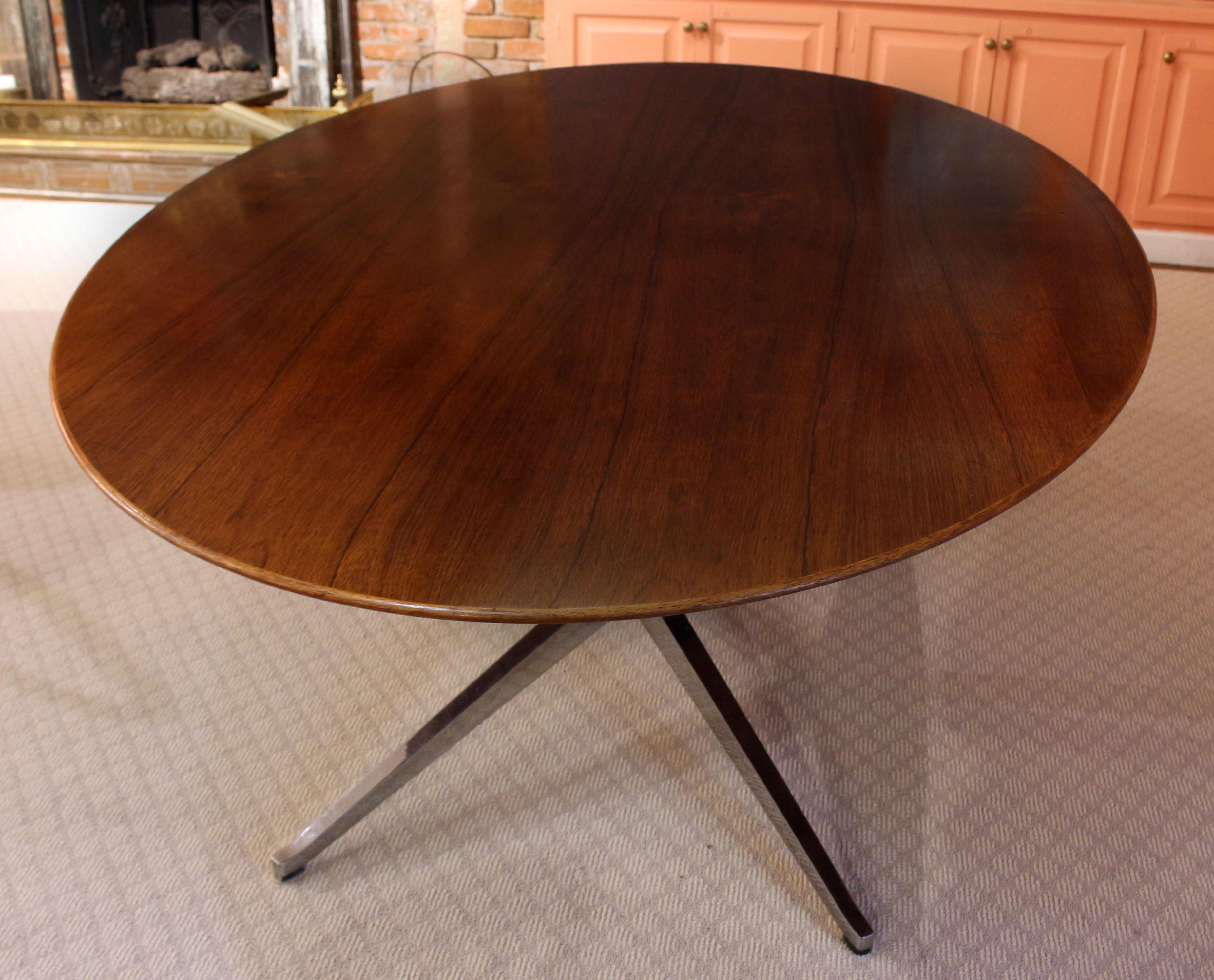 1960s Florence Knoll Oval Dining Table Made by Knoll. Original factory sticker under pedestal table supports: Knoll Associats, Inc, 320 Park Ave, NY, NY. Elegant rosewood veneer top with thin edge bevelling to a thicker slab creating a sleek,