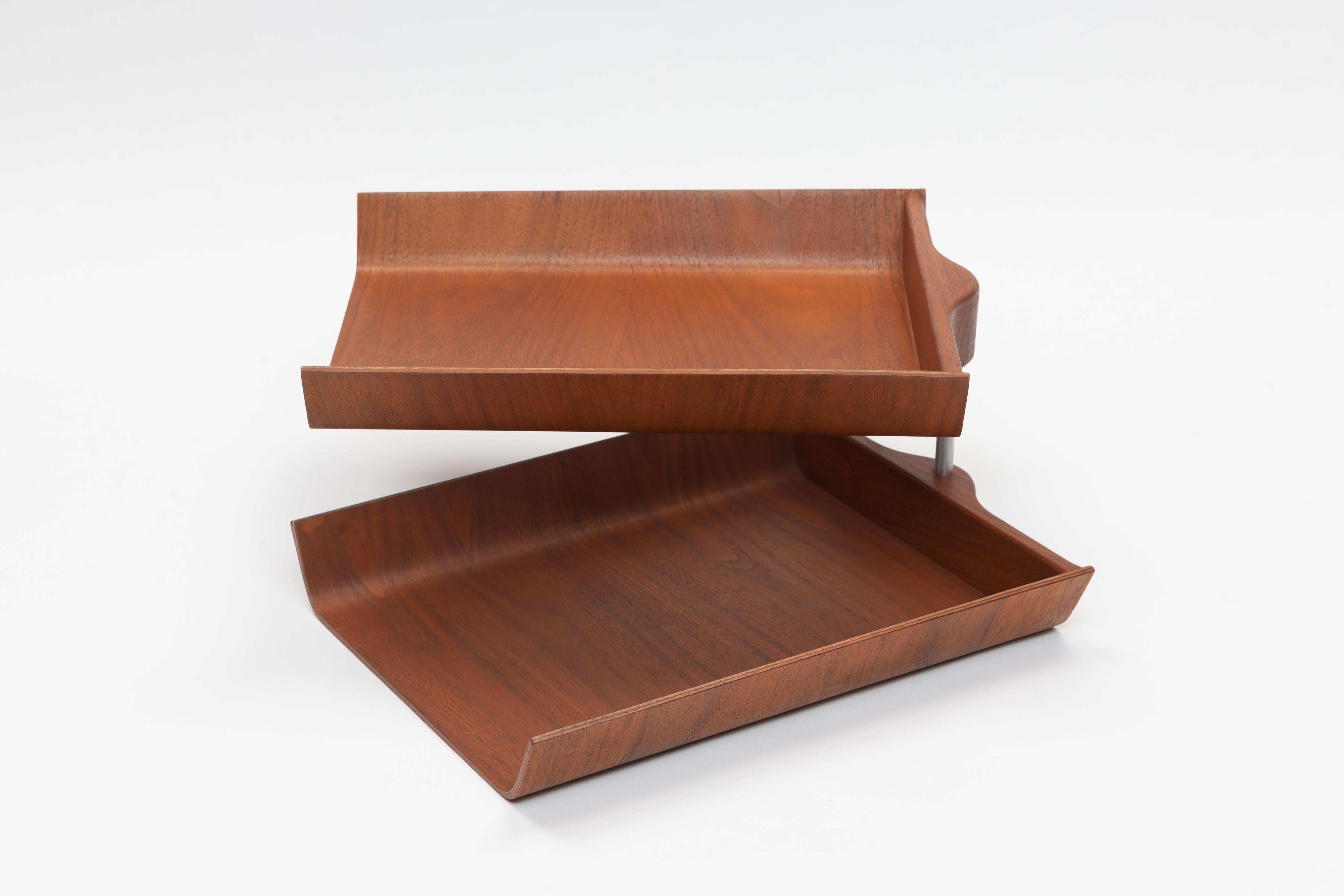 This double pivoting desk tray was designed by American designer Florence Knoll in 1948 and is a collectable midcentury accessory. The trays are made of walnut plywood with a solid wooden back pivoting on a metal support.
The underside of one of