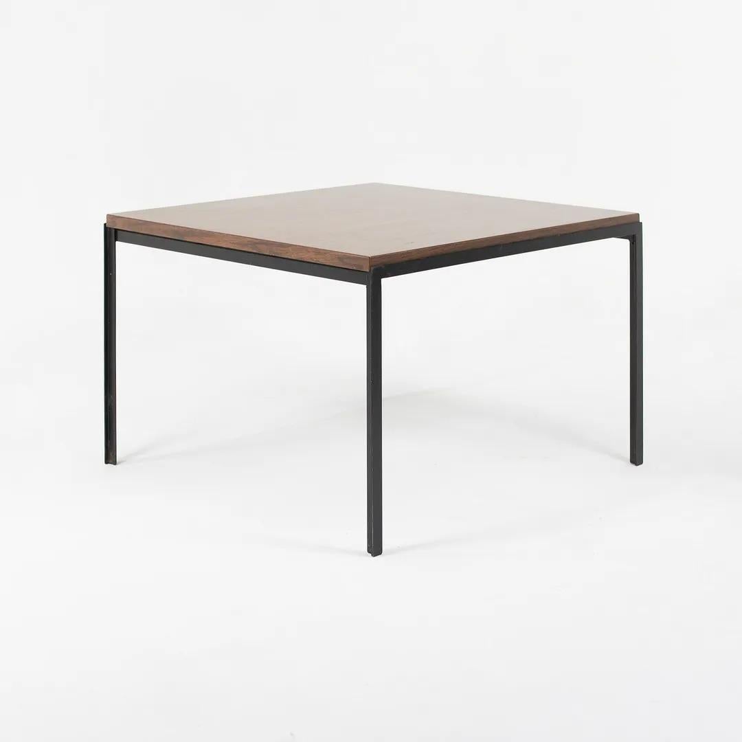 This is a Florence Knoll T Angle End Table, Model 304, originally designed in 1952. It features a square top with a walnut woodgrain laminate (formica) surface, and has black enameled steel legs. This particular example was produced in the 1960s. It