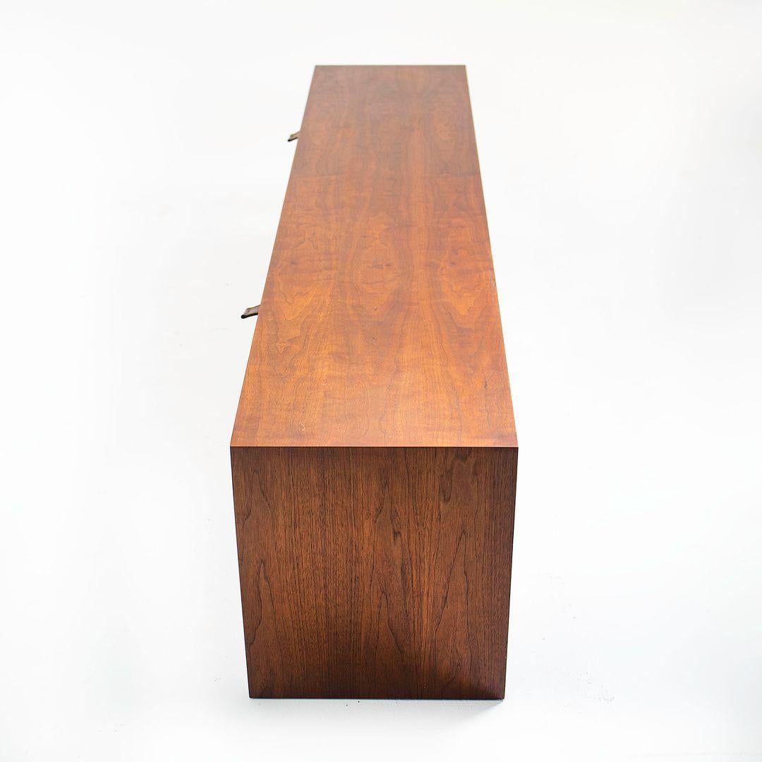 Si tratta di una credenza galleggiante da parete, modello 121 W-1, progettata inizialmente da Florence Knoll per Knoll Inc. nel 1956. Questo esemplare risale ai primi anni '60. Il pezzo è caratterizzato da una cassa in noce e da due ante a ribalta