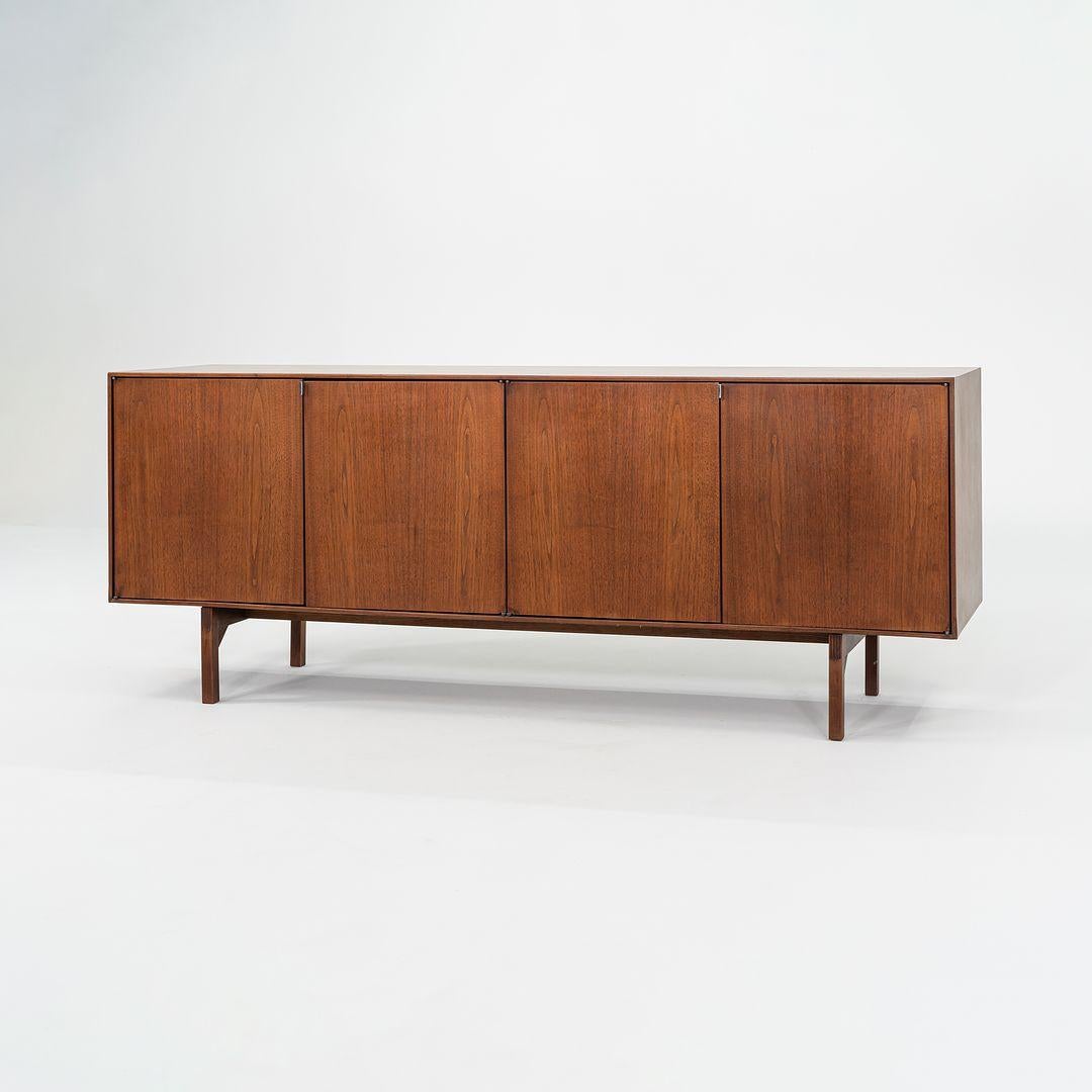 Questa è una credenza a 4 ante in noce, modello 541, disegnata inizialmente da Florence Knoll nel 1952. Questo particolare esemplare risale agli anni '60. Il pezzo è realizzato con un'impiallacciatura esterna in noce a grana grossa e