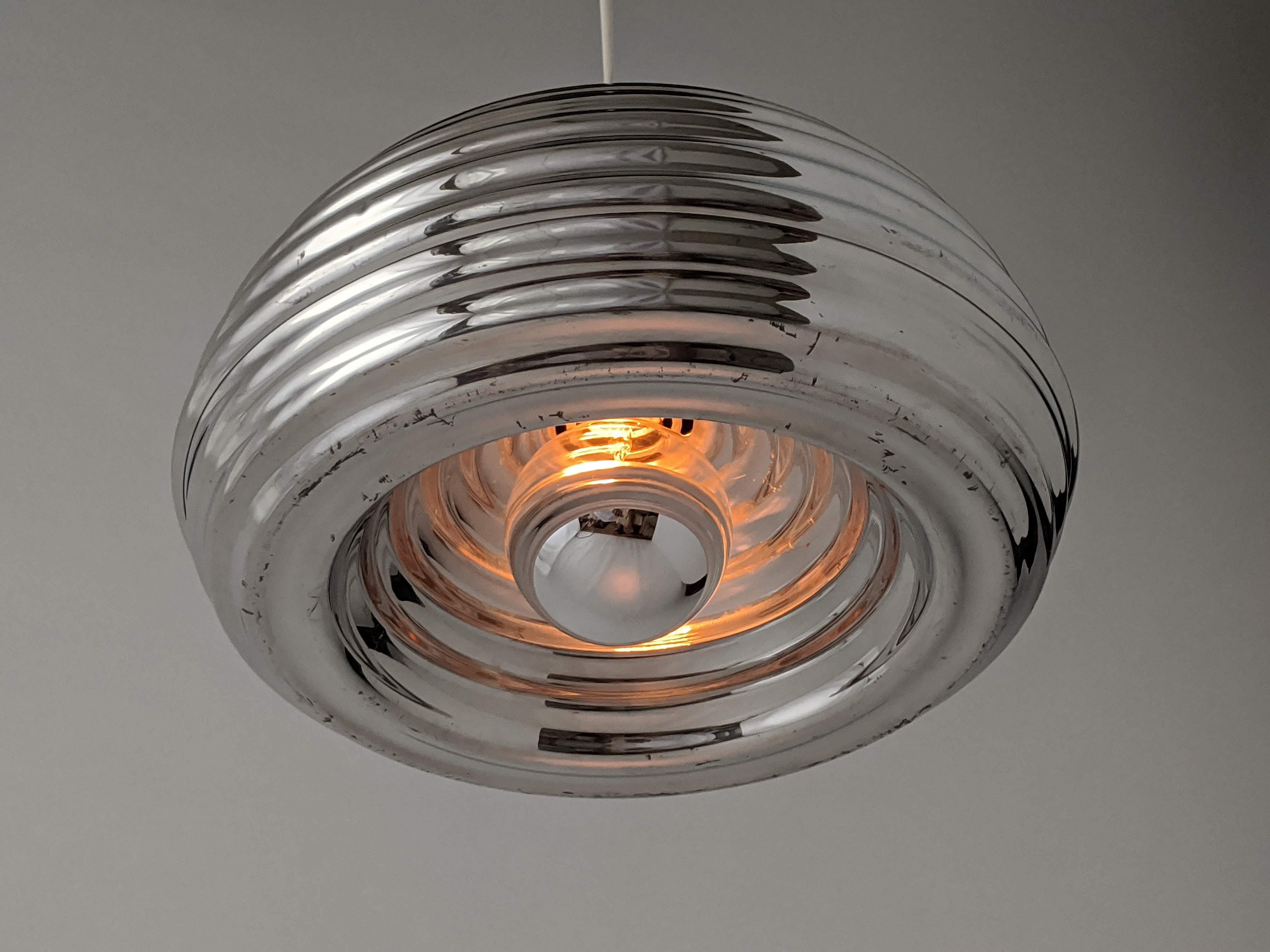 Original non lacquered early edition of this intriguingly designed pendant made of polished aluminium. 

One E27 size ceramic socket rated at 100 watt. 

Mirror top light bulb supplied with order. 

Come with 5 feet of wire with chrome