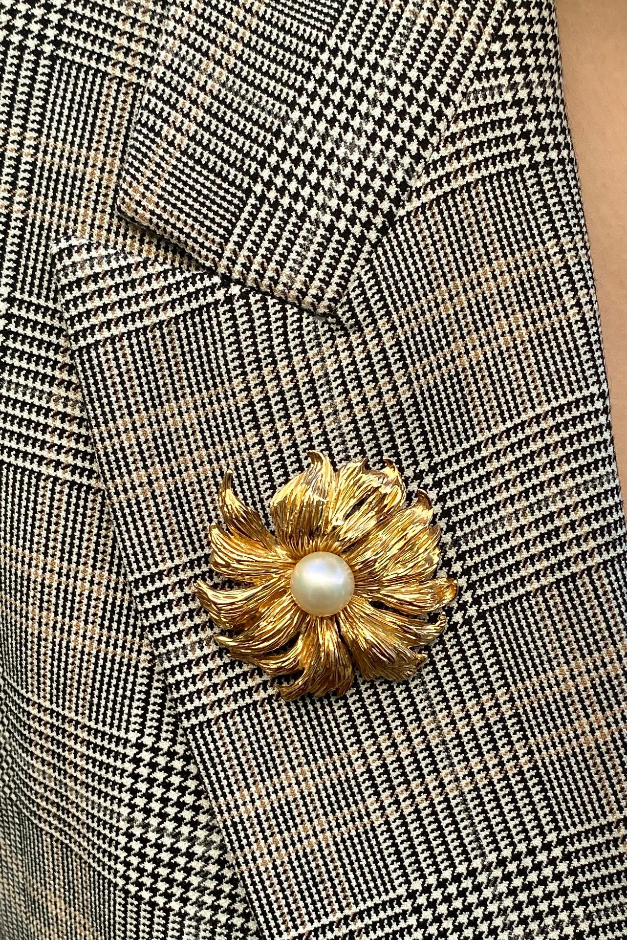 A beautiful vintage flower brooch rendered in solid 14K yellow gold with a cultured pearl at the center and a pin closure.

The brooch measures 42.5mm (1 2/3 inches) in diameter, and the central pearl measures 9.7mm in diameter. It weighs 17.7 grams