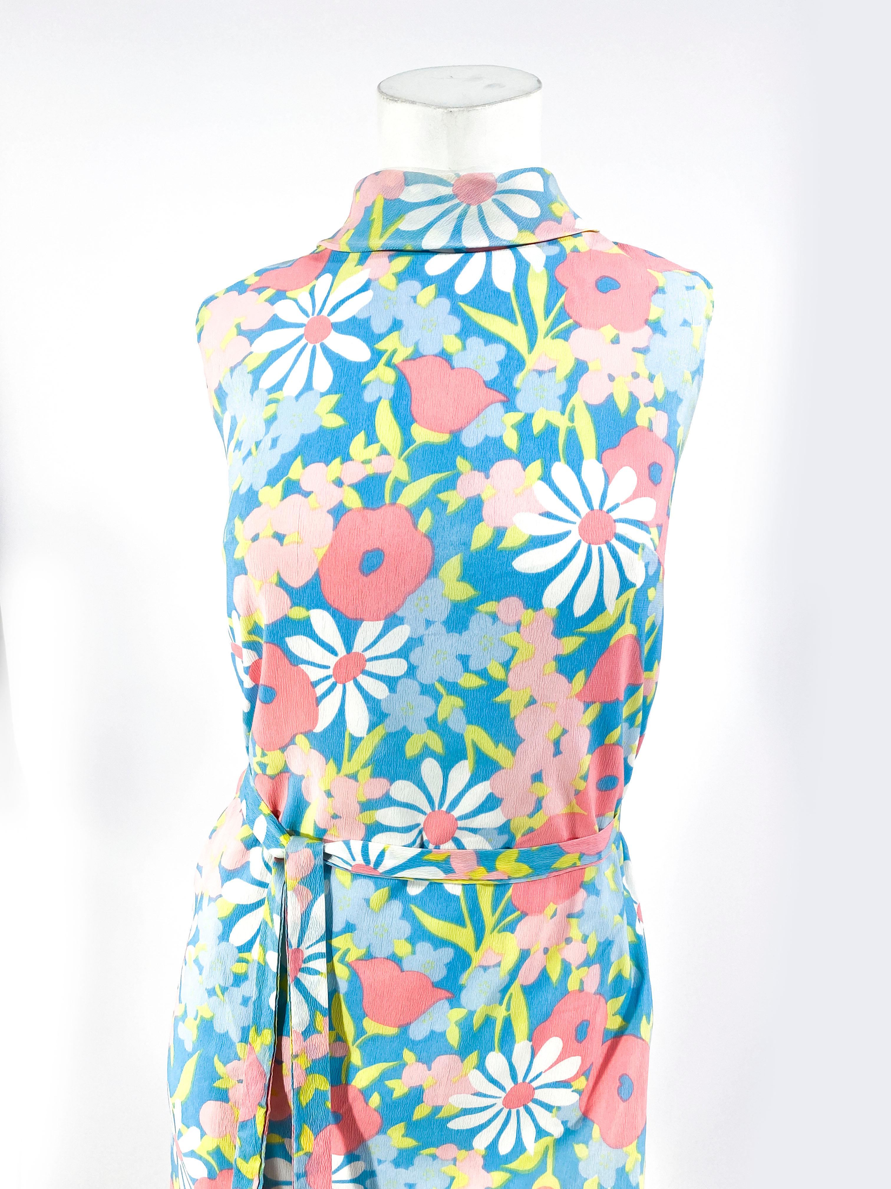 1960s flower printed shift dress made of a polyester crepe and a turtle-boat neckline. The dress is entirely lined with a back metal zipper closure and a matching sash.