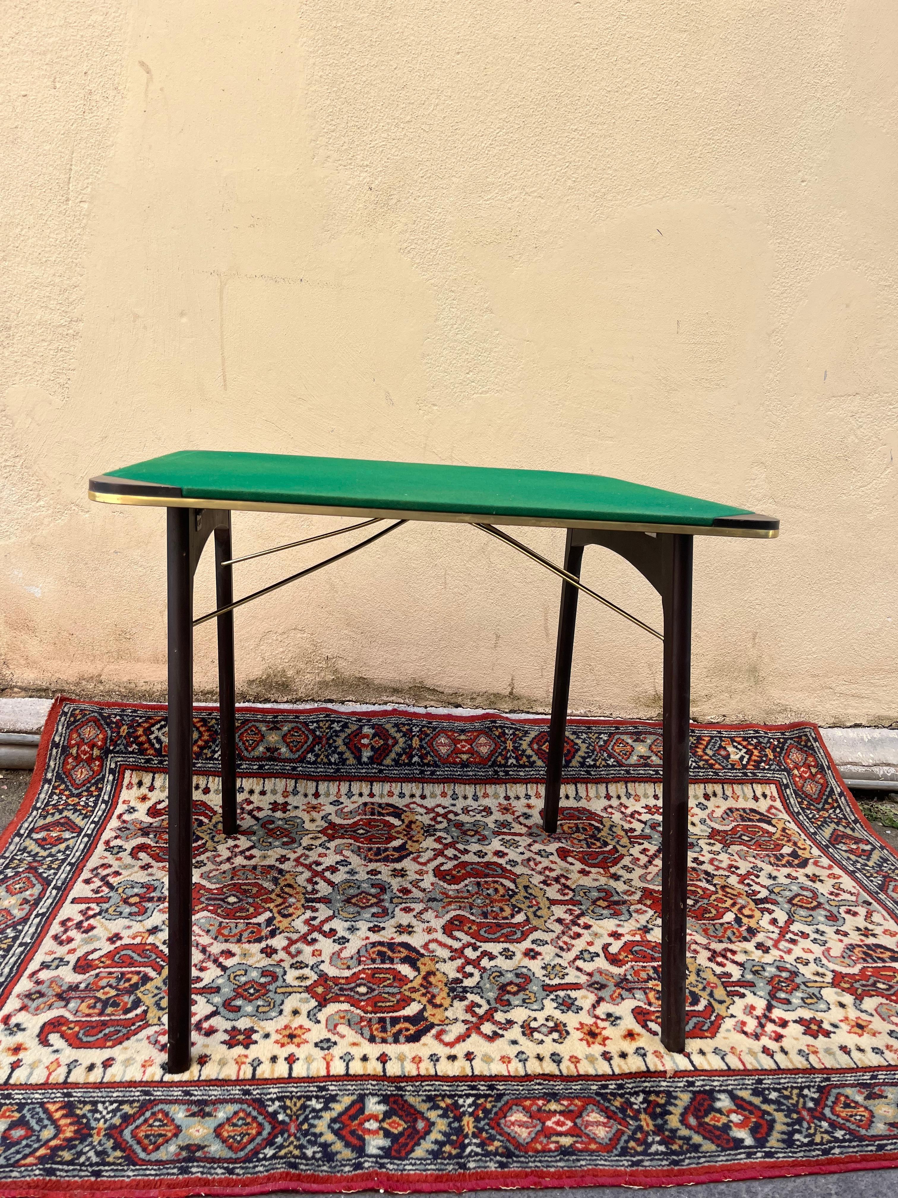 folding game table in wood and fabric from the 60s. There is something deeply fascinating in the small rituals of conviviality, especially when they take place around an object that carries with it the memory of an era. This game table from the 60s,