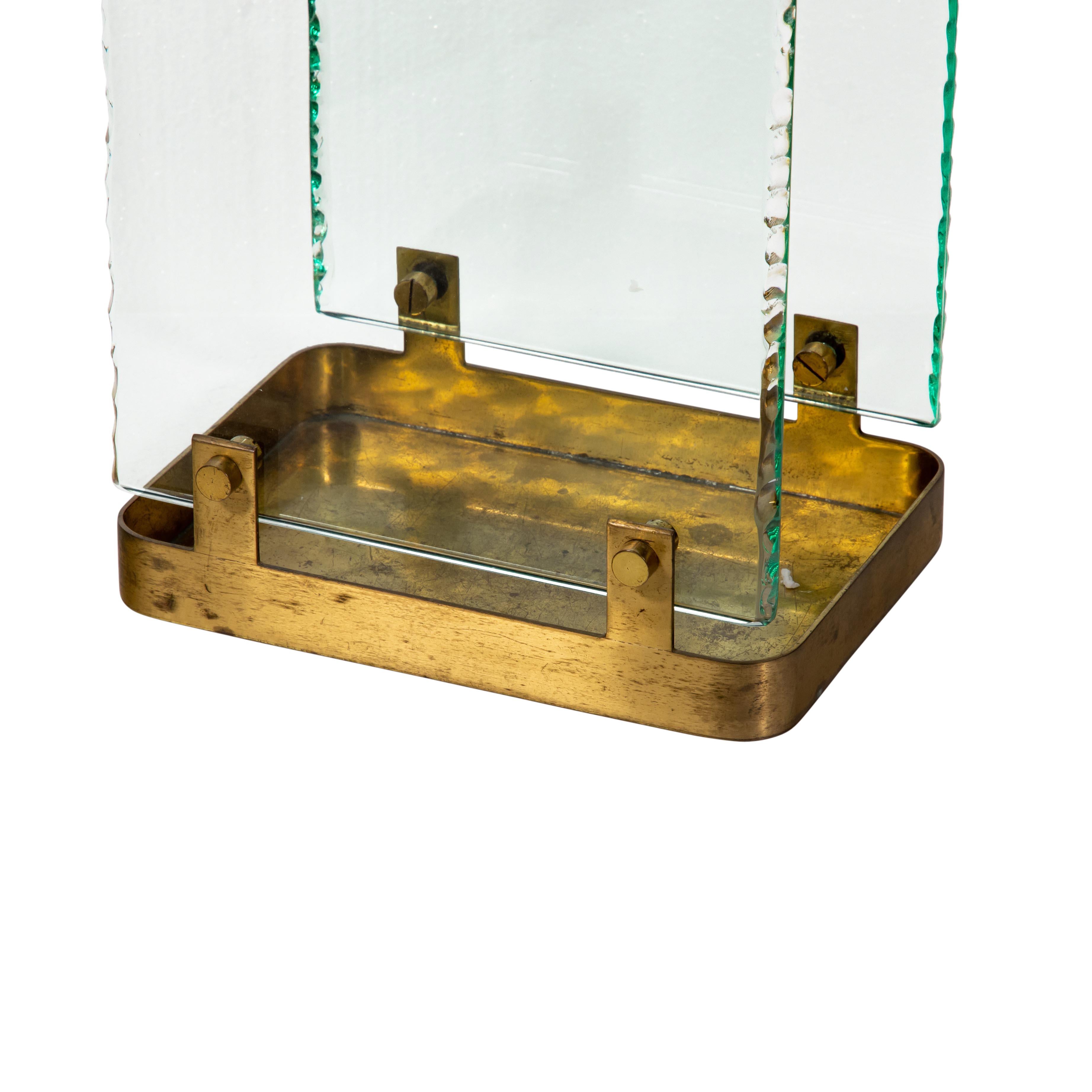 A stunning vintage 1960s umbrella stand. Italian design by Max Ingrand for Fontana Arte.
Rectangular brass base with rectangular brass top edge secured with brass screws to two clear light aqua mare colour glass panels.
Very beautiful and elegant.