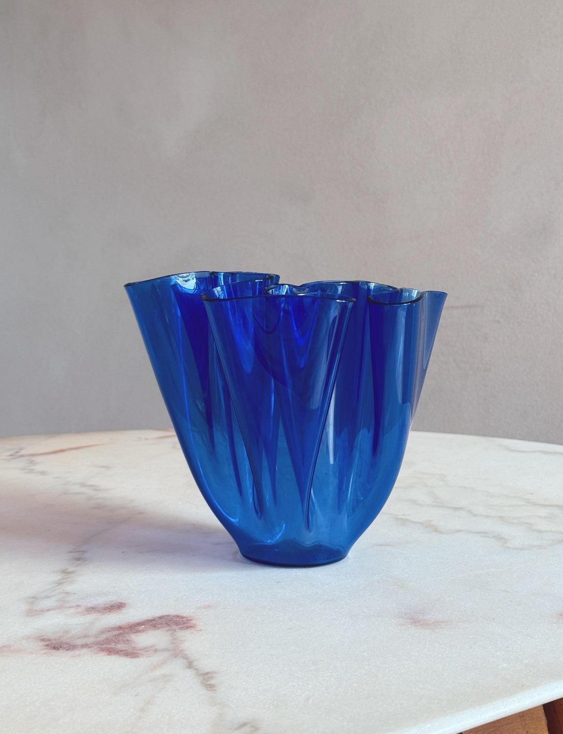 A small dark blue Fontana Arte 1960s 'Cartoccio Vase'. The glass is wonderfully folded to create the iconic 'cartoccio' / tissue effect vase. This vibrant piece looks wonderful with our small collection of Fontana tissue vases.