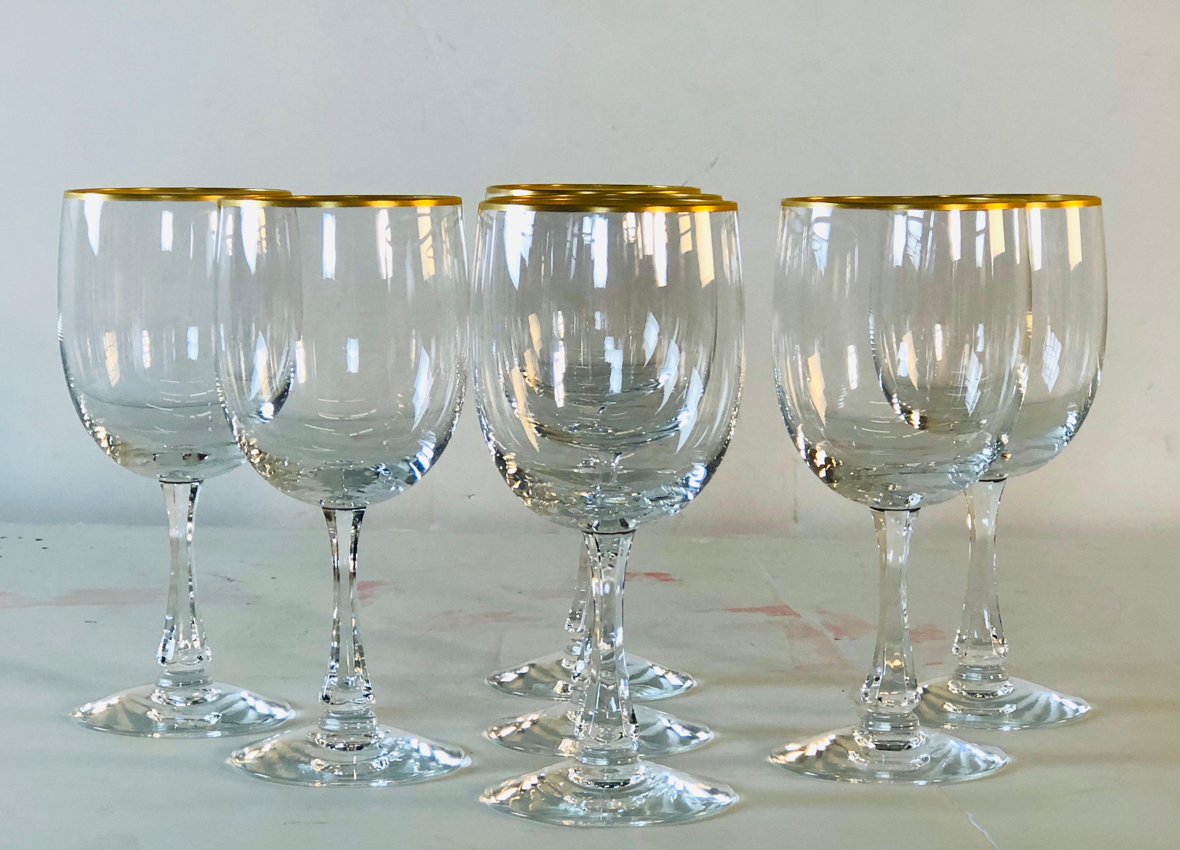 Vintage 1960s set of 7 Fostoria Glass gold rim water or wine glass stems. Marked underneath. Excellent condition.
            