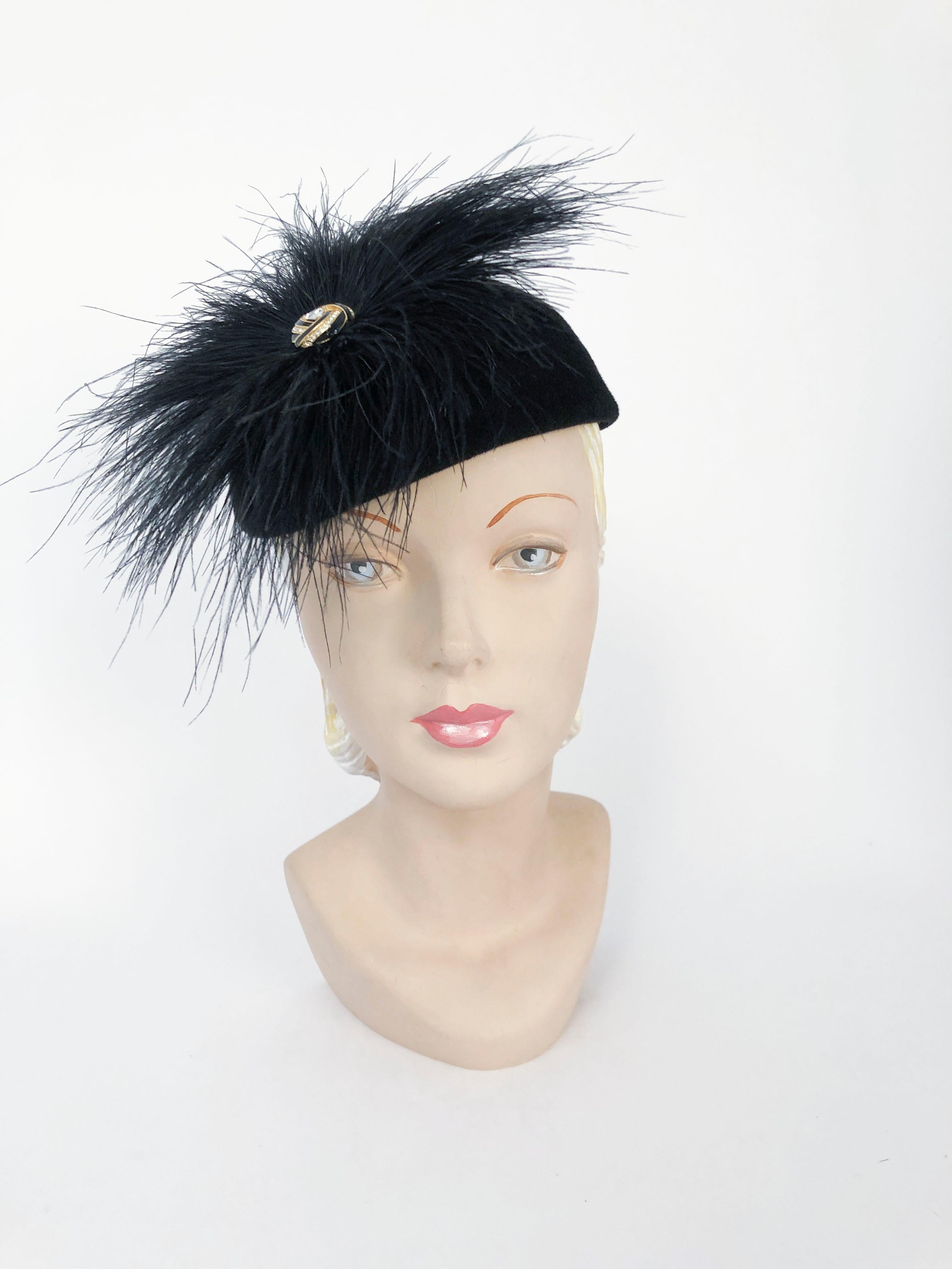 1960s Black Cashmere Hat with Feather Accent. Black cashmere hat with an accent of fanned feathers centered with clearstone, black enamel, and gold wash piece