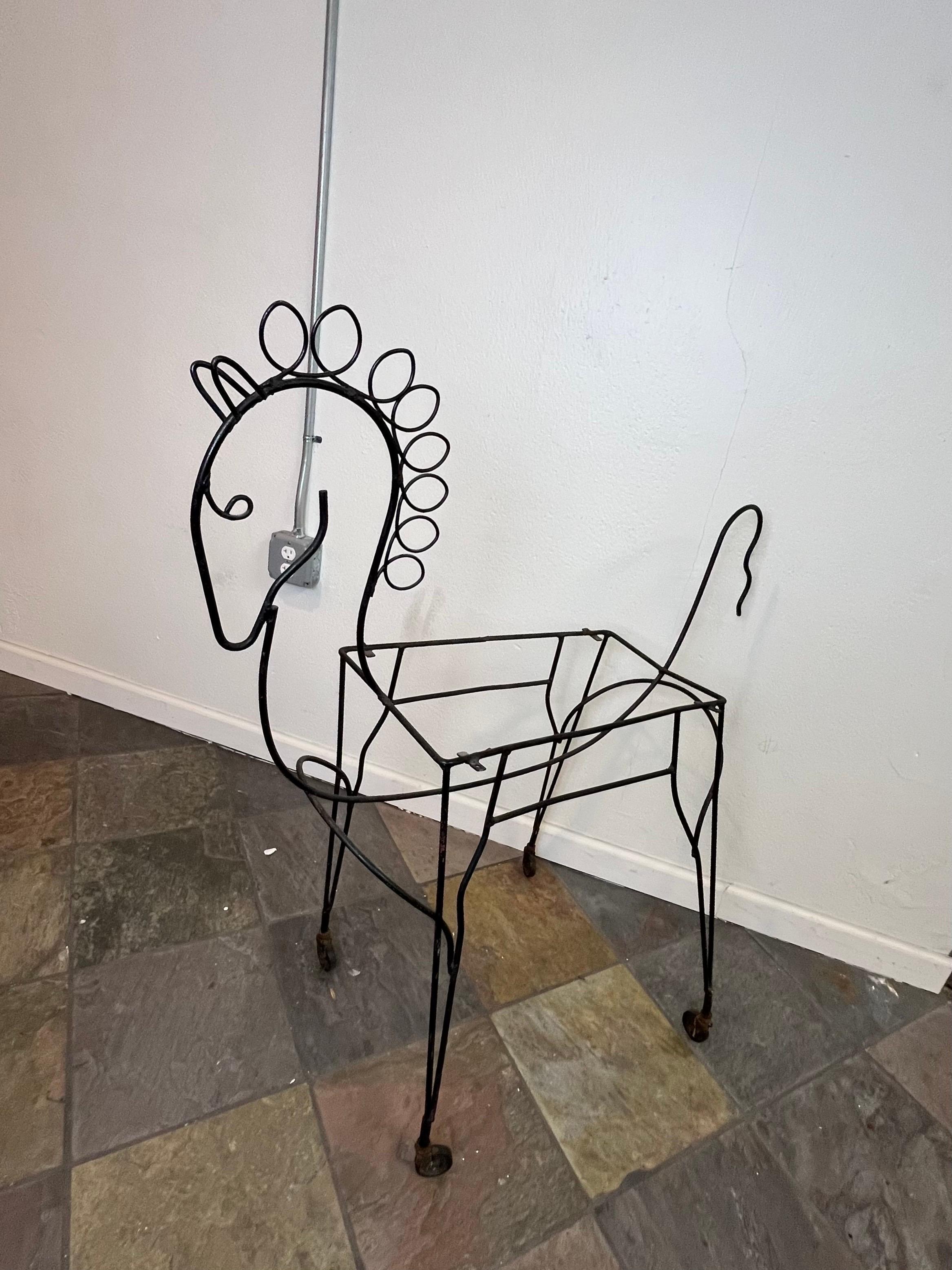 This horse-shaped bar cart in the style of Frederick Weinberg, showcases an iron frame that embodies the mid-century modern aesthetic—clean lines, and geometric shapes. The meticulously refinished iron frame gives the cart a sleek and lustrous