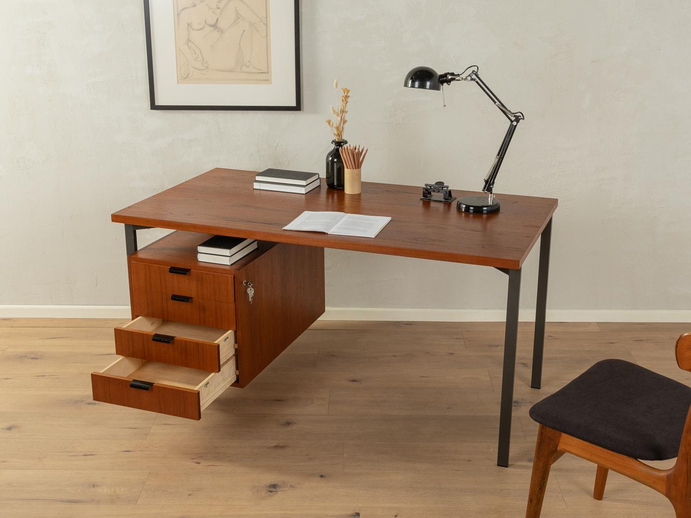 Scrivania classica indipendente degli anni '60 nello stile di Herbert Hirche. Corpo e piano di lavoro in impiallacciatura di teak. Struttura in metallo di alta qualità di colore nero, un contenitore impiallacciato in teak, quattro cassetti e uno