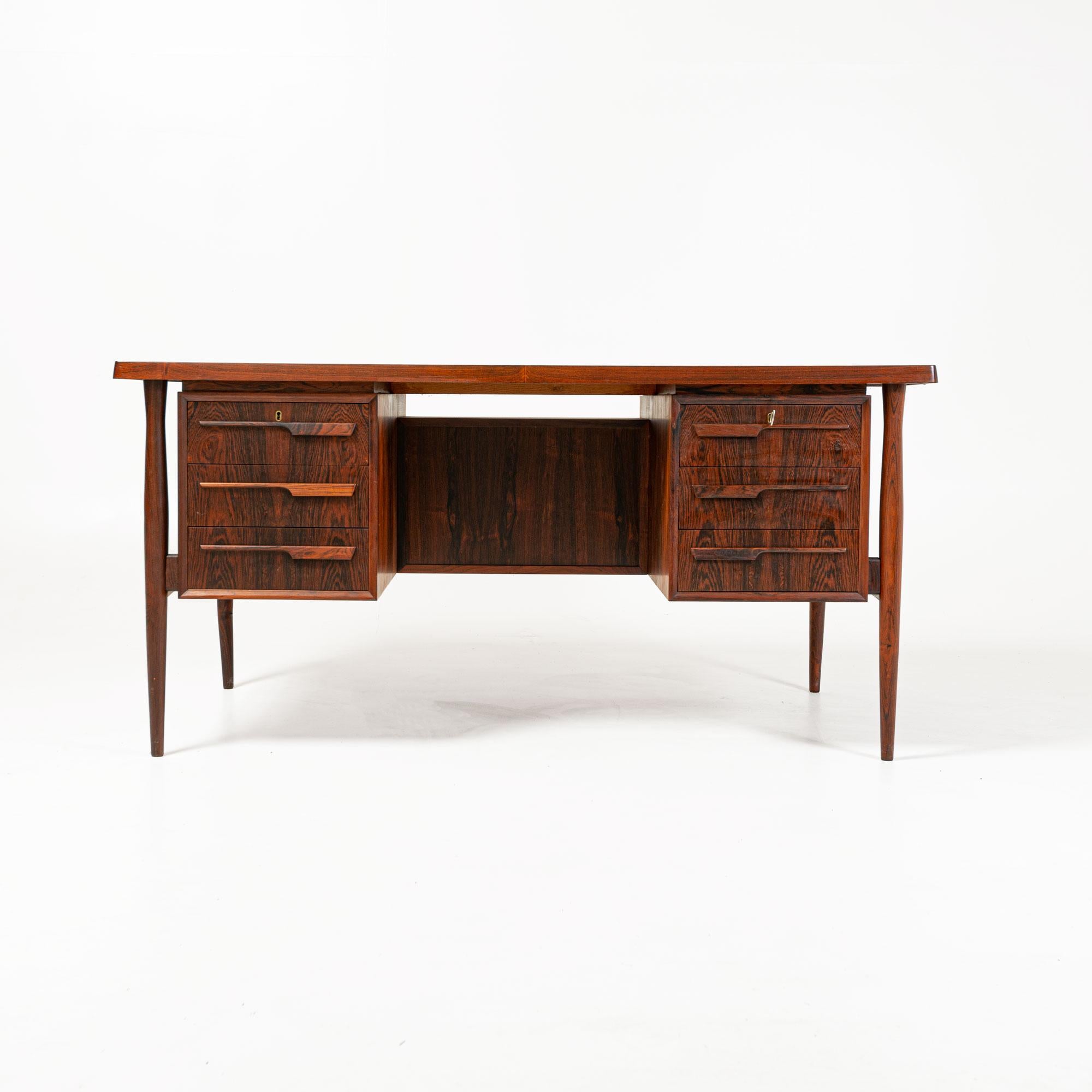 An unusual free standing Danish rosewood desk designed in the manner of Arne Vodder. 

Arne Vodder was trained by Finn Juhl, who became his friend and business partner. Before concentrating on furniture alone, in 1951 he opened his own studio with