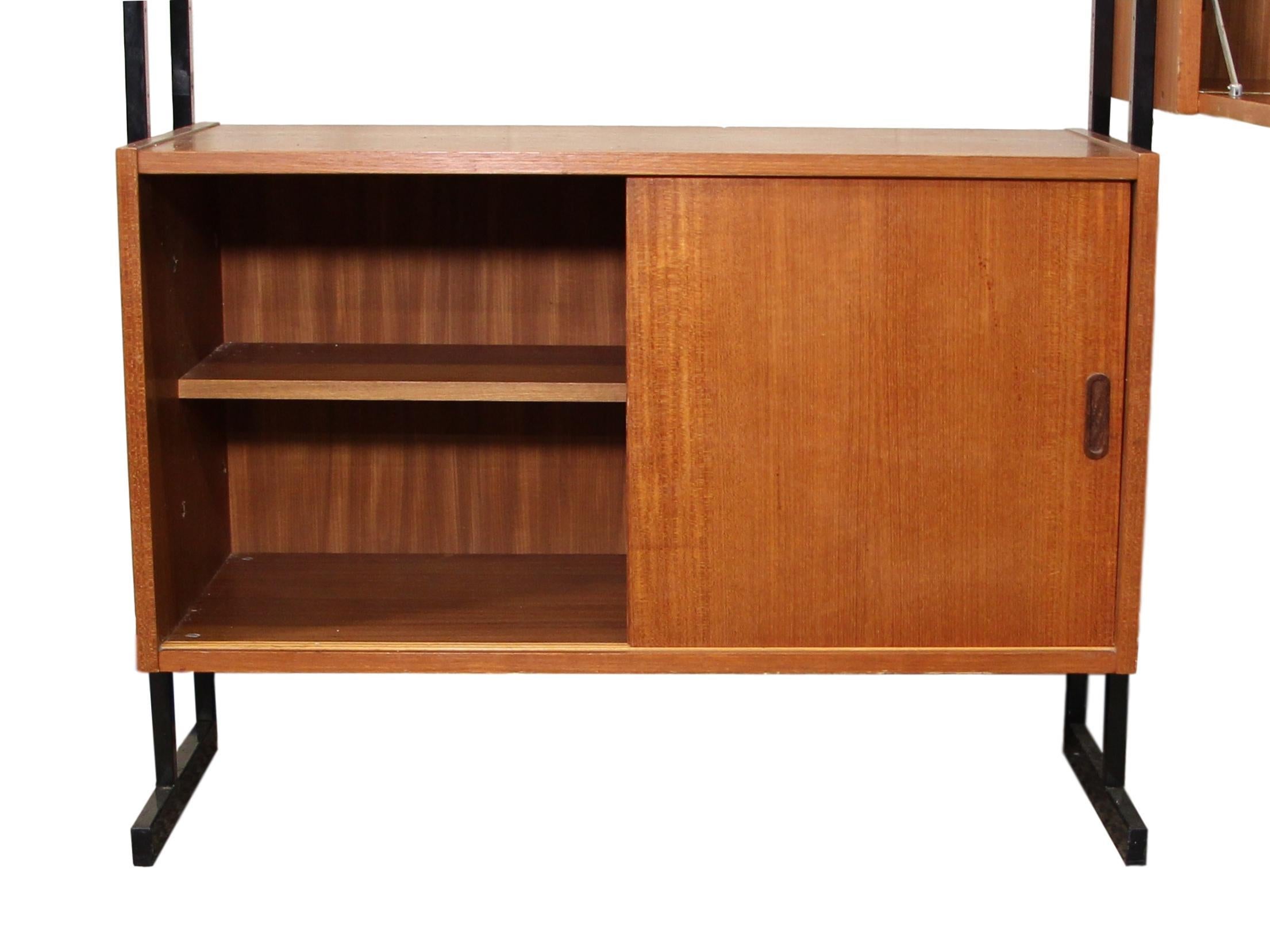 This is a 1960s adjustable 3 bay wall unit made by Interflex, UK, 
The height is fully adjustable. It features 1 top sliding glass door cabinet, 1 sliding door base cabinet, 1 drop down door cabinet, 1 three door cabinet, and 1 shelf. 

Very good