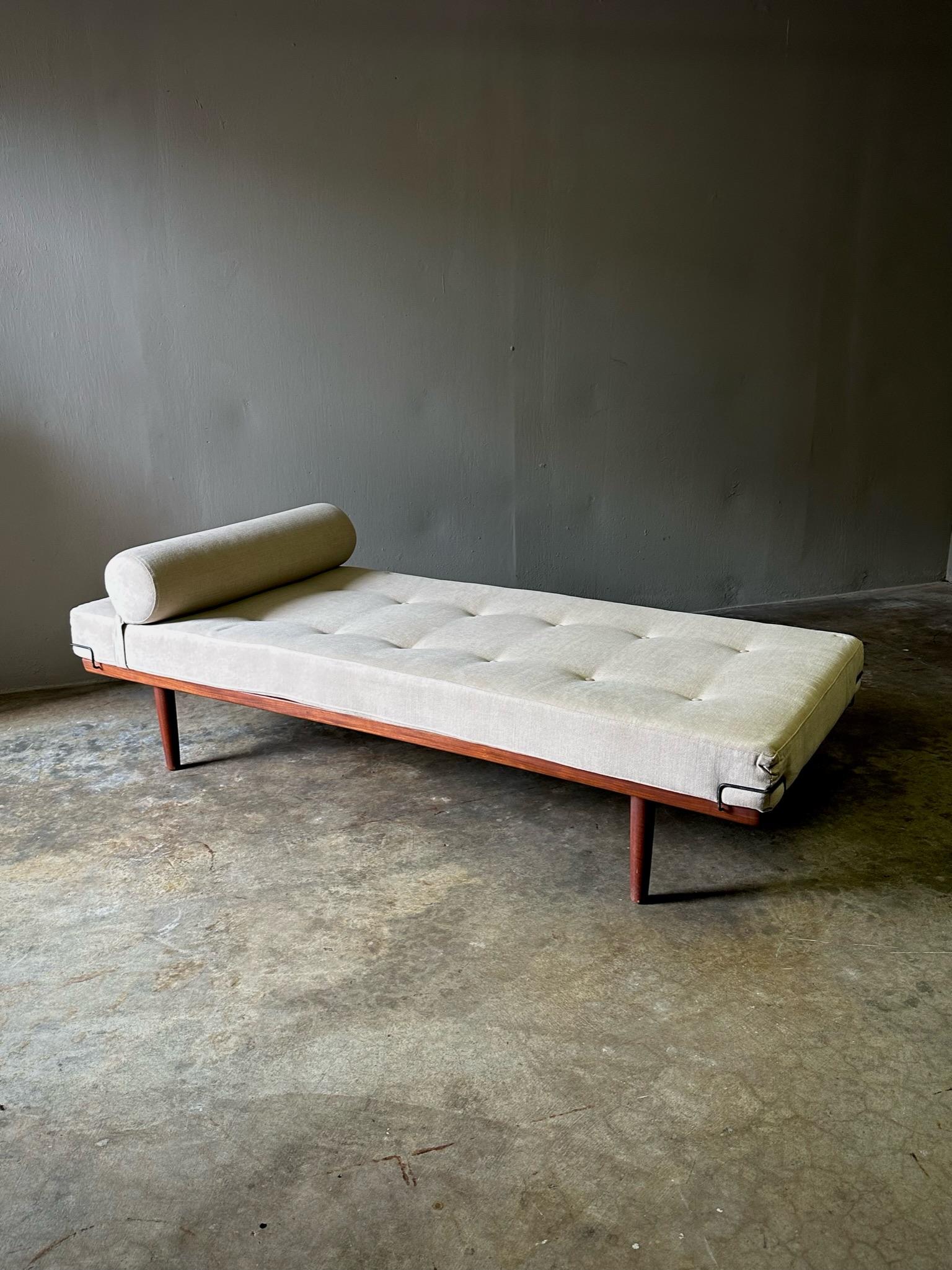 Rare Danish midcentury daybed by Frem Rojle, with sleek modern lines, wood base and ecru upholstered seat cushion with bolster pillow. Sensuous yet minimal. 
