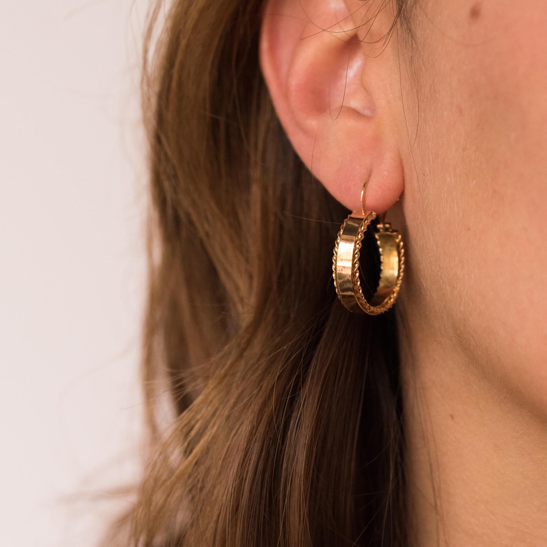 For pierced ears.
Earrings in 18 karats rose gold, eagle's head hallmark.
Lovely antique hoop earrings, they are composed of a flat gold ring bordered on either side of a thin gold cord. The fastening system allows to put the earrings from the front