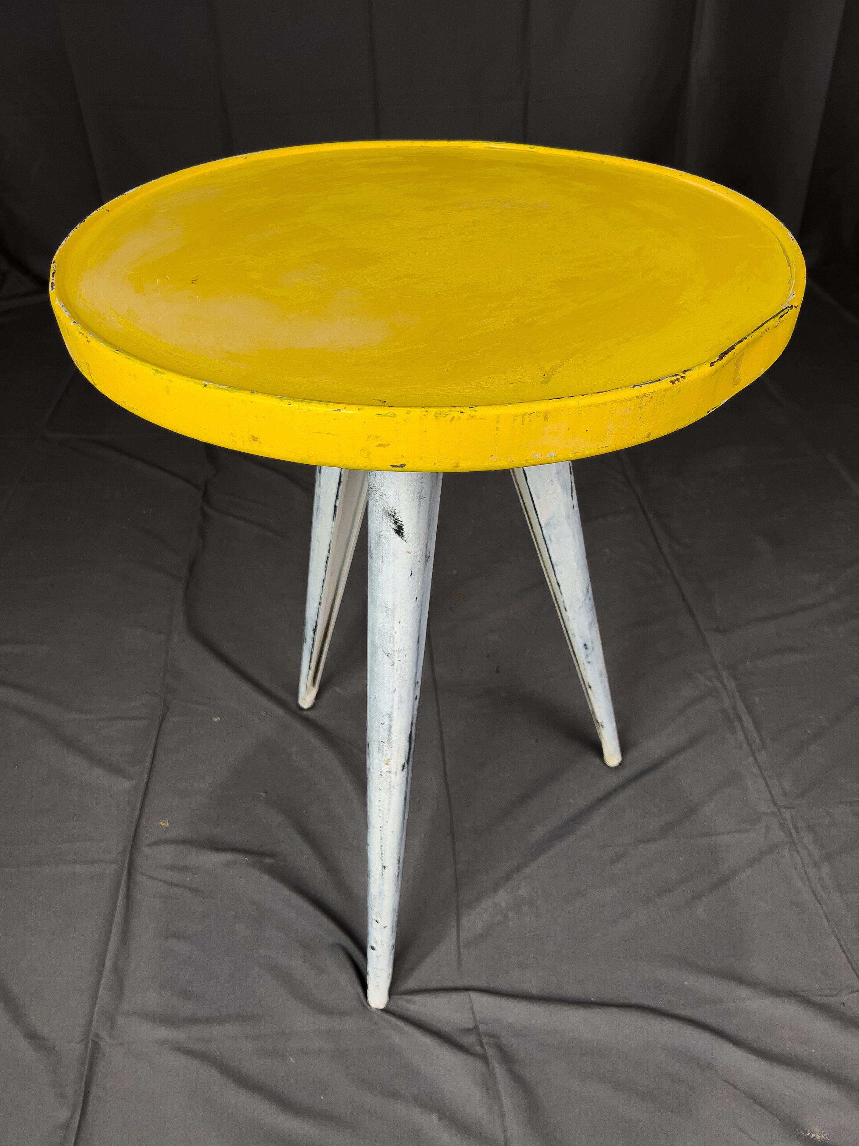 1960s French bistro tables having a bright yellow round top and three canted legs.