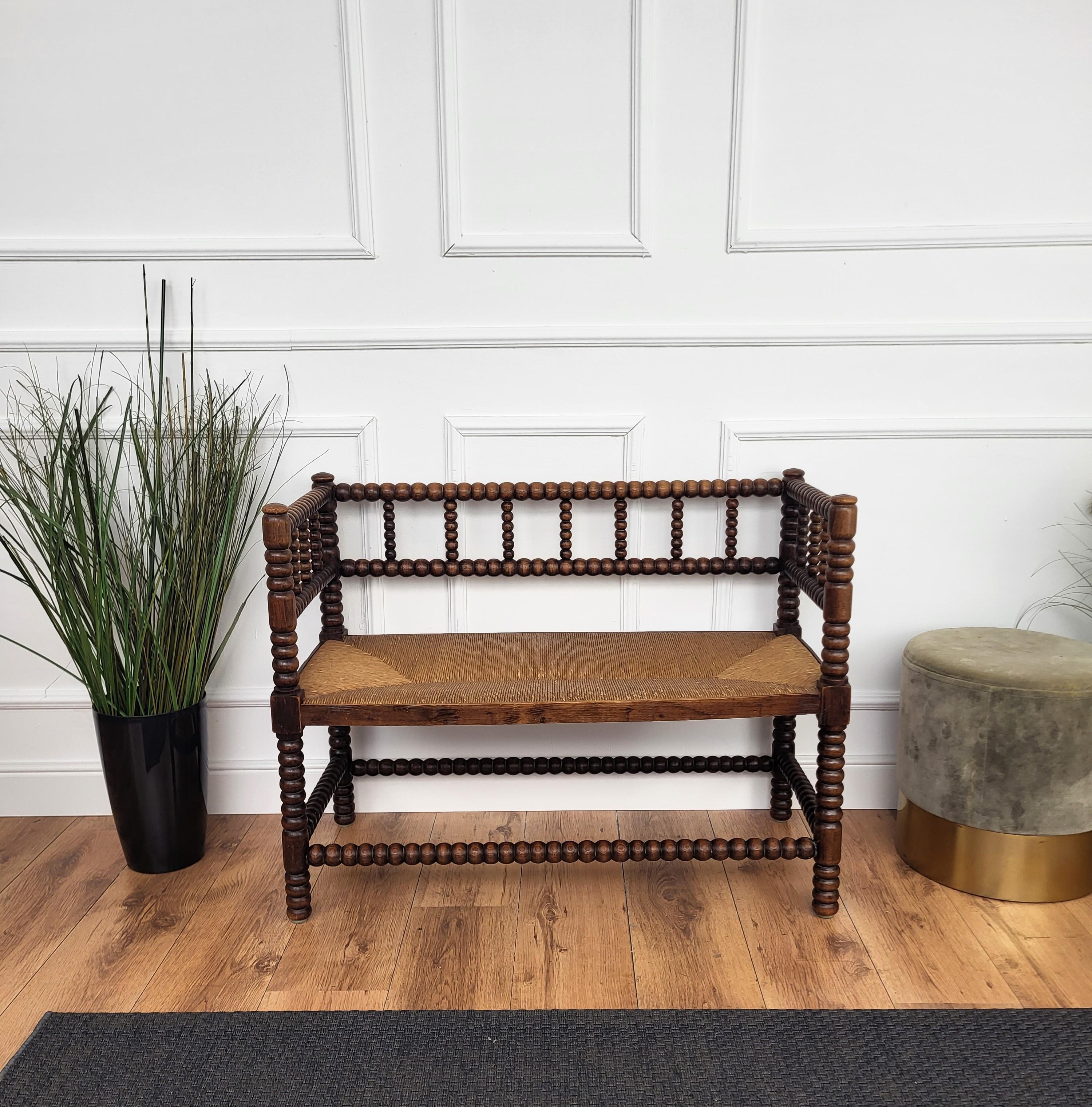A charming dark wood stick and ball craftmanship bench with original rush seat. We do have available as well the matching corner chair.