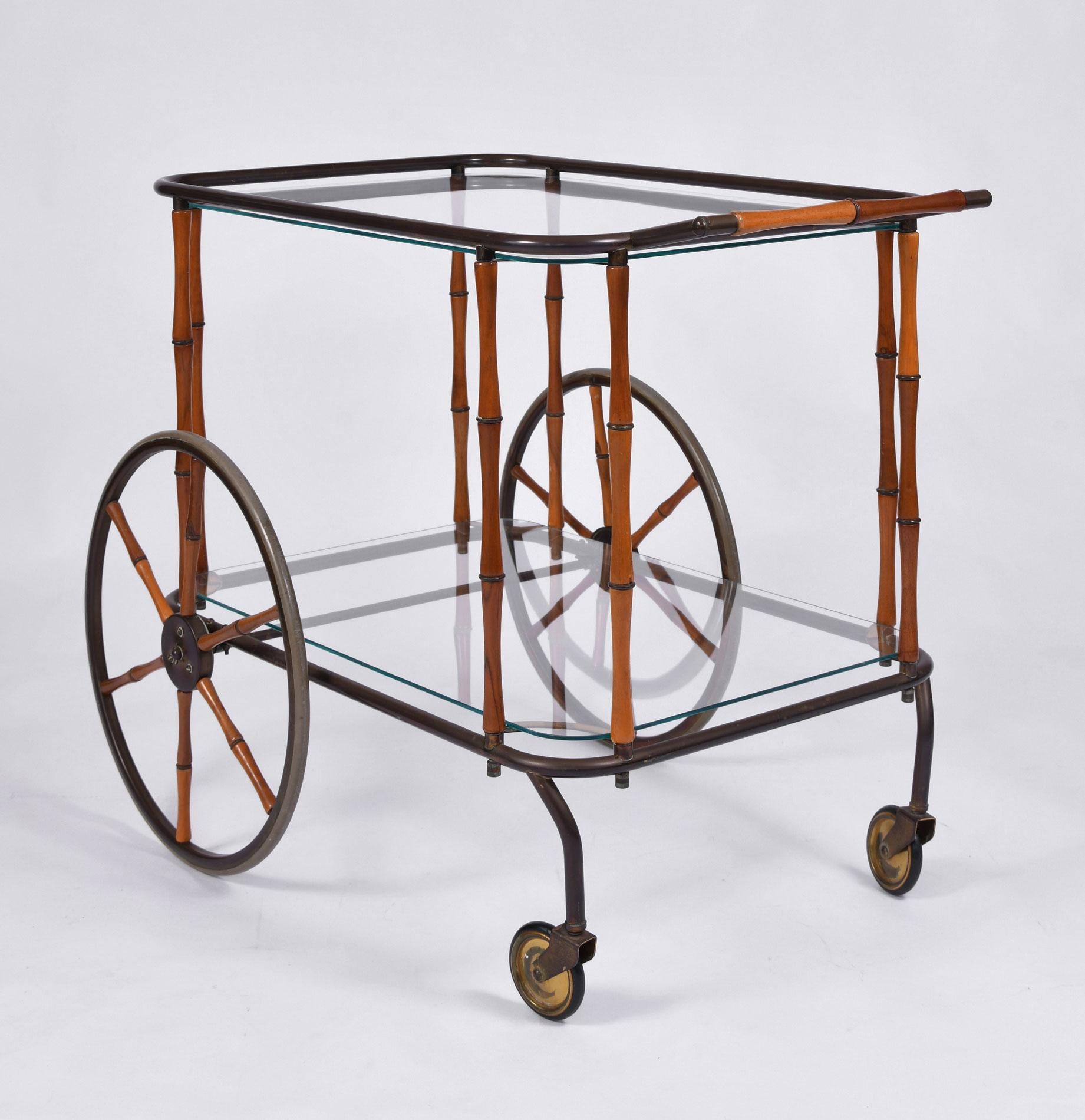 Well proportioned Hollywood Regency drinks trolley /bar cart with two glass shelves. Brass frame with bamboo handle, sides and decorative oversized wheels.
 