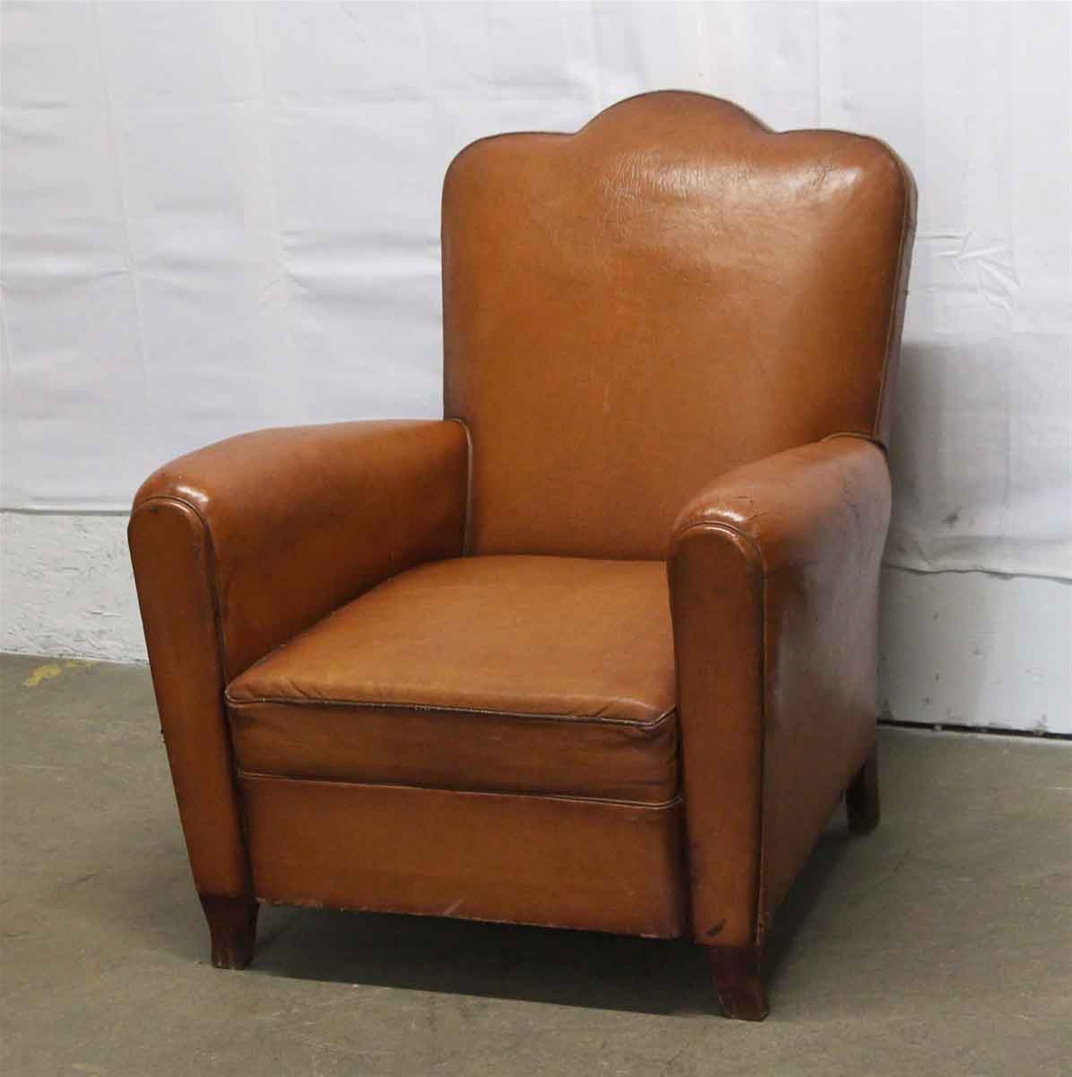Brown leather 1960s French club chair with wooden feet and a studded back. This can be viewed at one of our New York City locations. Please inquire for the exact address.