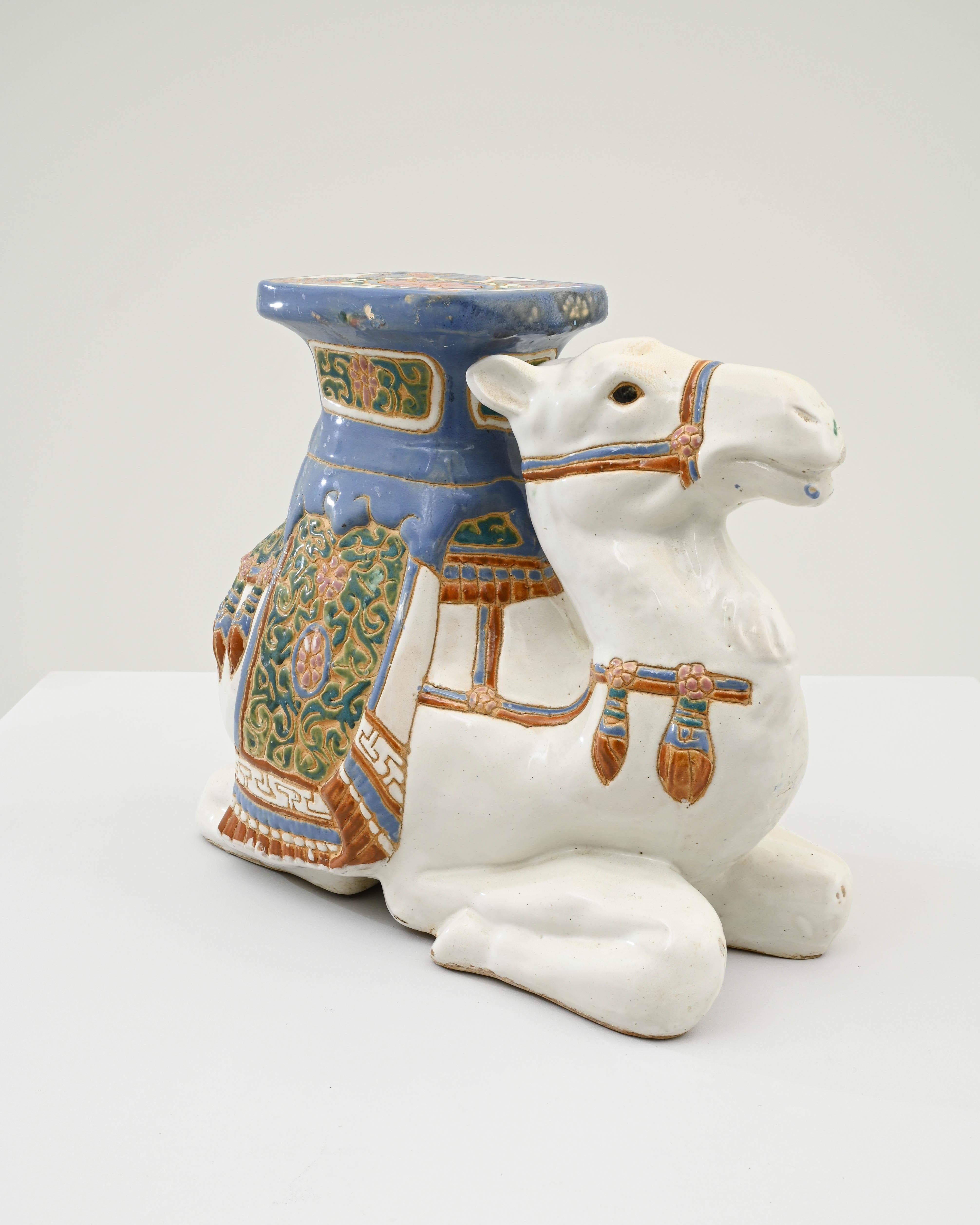 This ceramic sitting camel was crafted in France, circa 1960. A poised figure, this tranquil camel flaunts an immaculate white glaze and an impressive mahawi - camel saddle - ornamented with moresque motifs. The elegant fringes of the saddle are