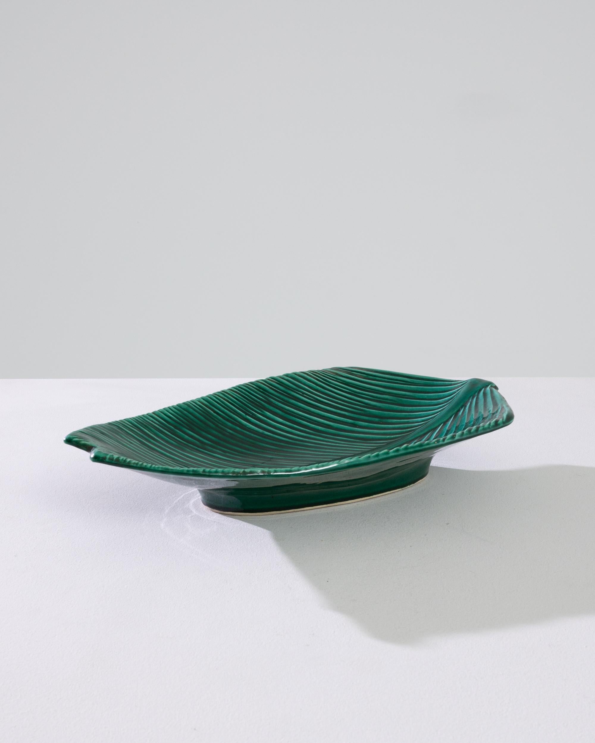 A ceramic plate from 1960s France in the shape of a leaf. A legend on the underside informs that this piece was made in Vallauris — a Mediterranean coastal town so famed for its pottery that Picasso went there to learn about ceramics. The
