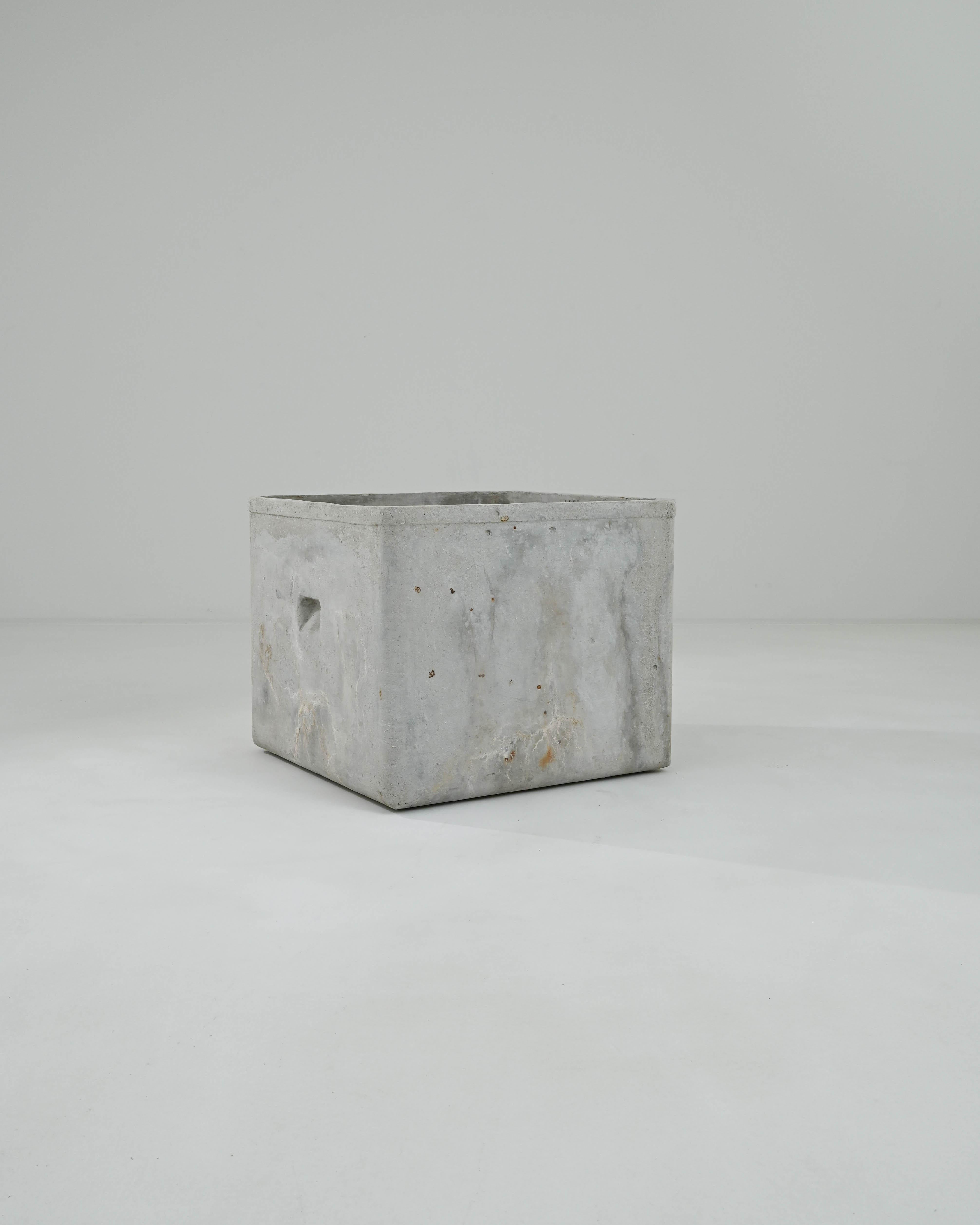 A minimalist shape combined with an evocative natural patina gives this vintage planter a unique personality. Made in France in the 1960s, the design has a simple appeal: a square container, unembellished save for the slight protrusion of the lip