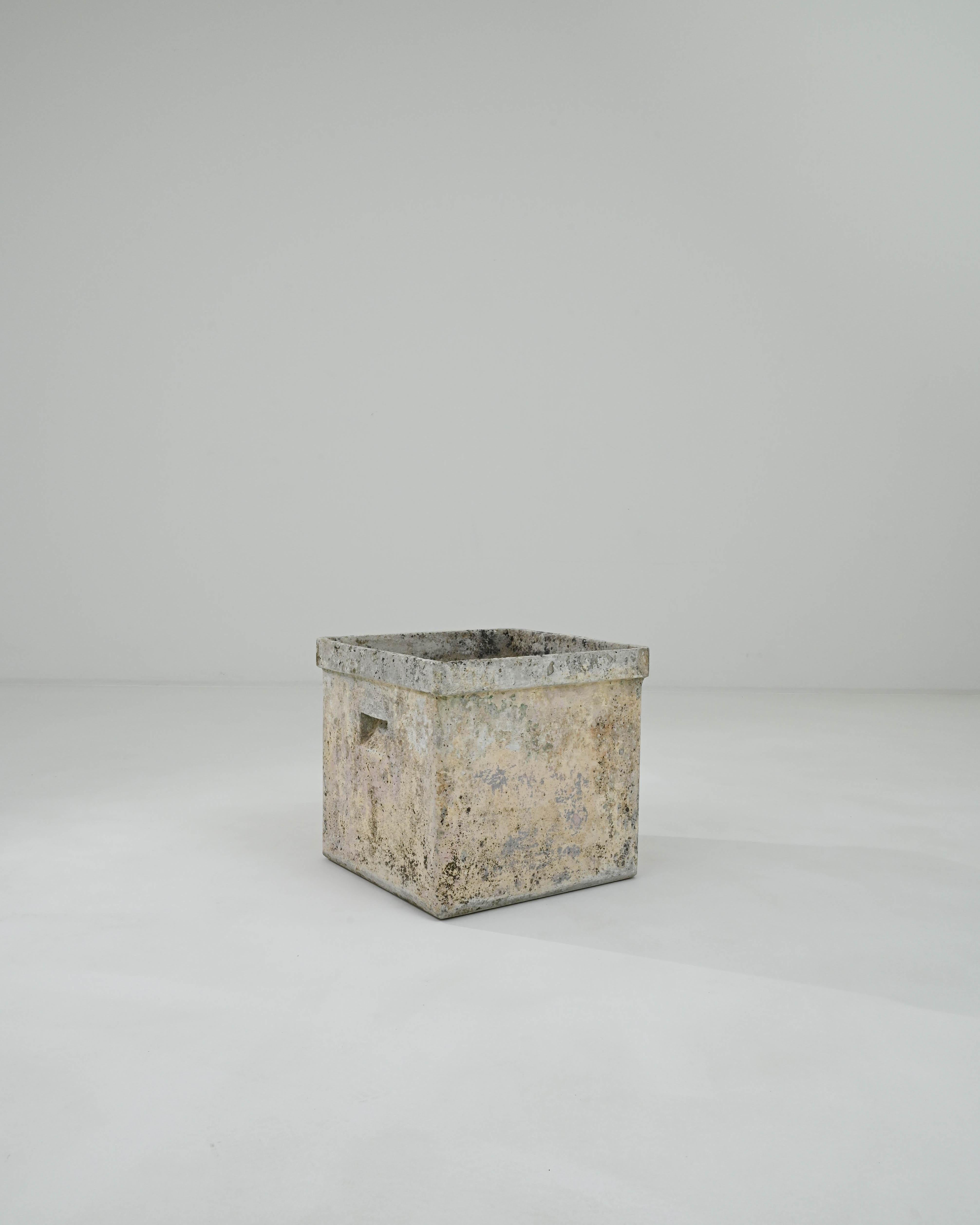 A minimalist shape combined with an evocative natural patina gives this vintage planter a unique personality. Made in France in the 1960s, the design has a simple appeal: a square container, unembellished save for the slight protrusion of the lip