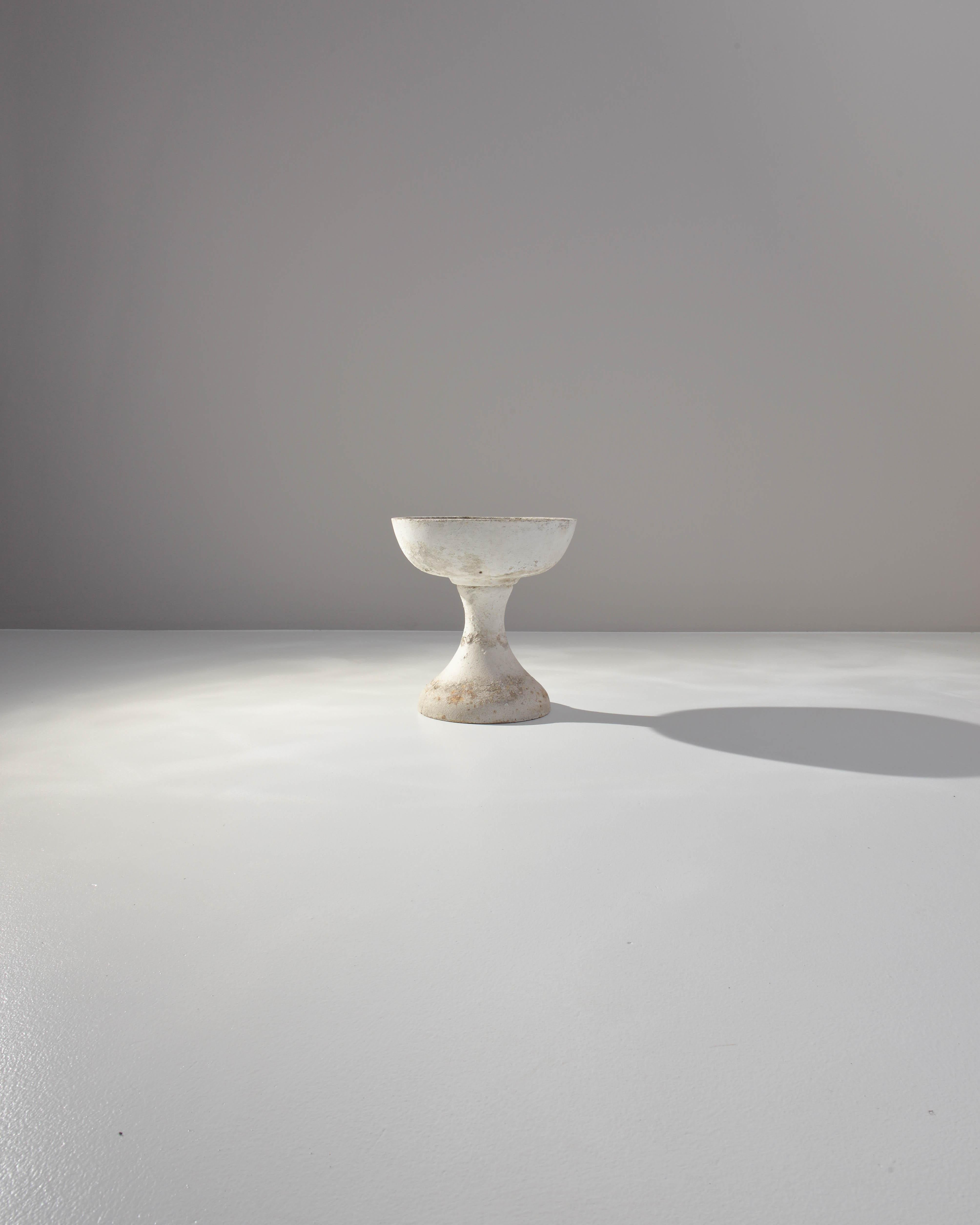 A concrete planter from France, produced in 1960. A deep bowl made from white patinated concrete set on a short stand like a chalice or champagne coup of the gods. Wear in original patination shows long life lived out of doors, absorbing rays from