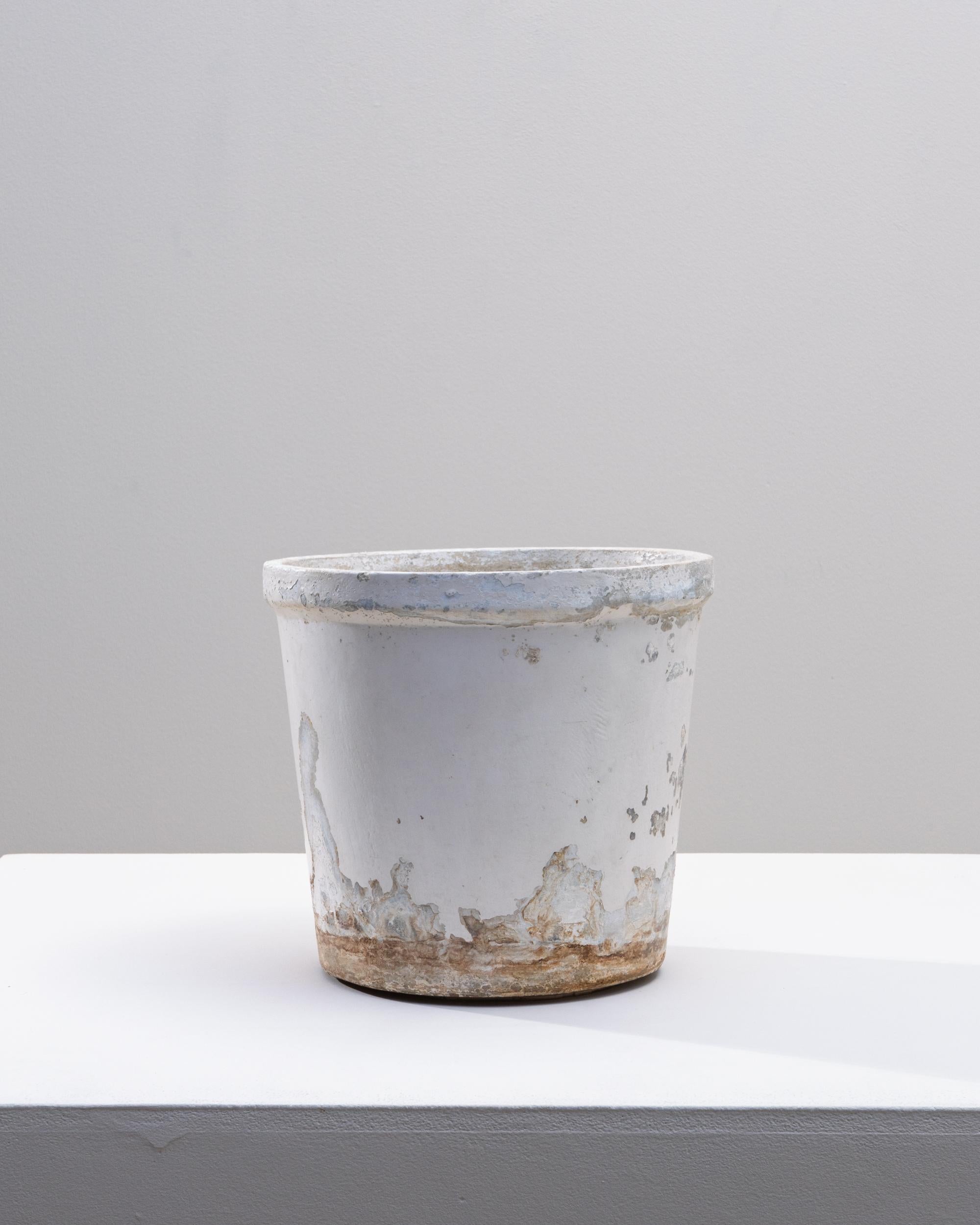 This 1960s French concrete planter features a classic cylindrical form accented by decades of natural weathering, giving it a beautifully worn, authentic patina. The original white surface has softened into layered tones of chalk, stone, and subtle