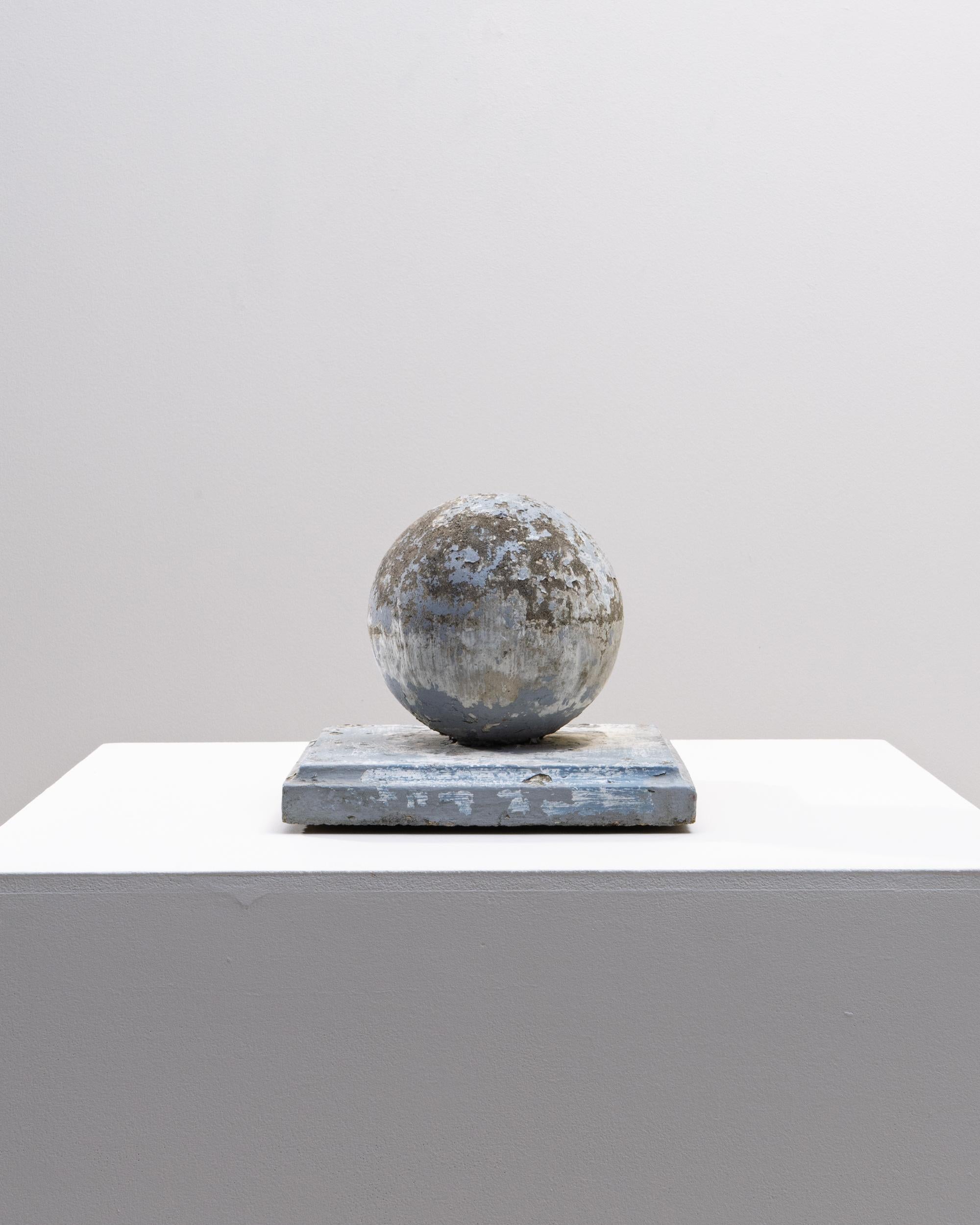 This 1960s French concrete sculpture presents a striking geometric composition, pairing a perfectly rounded sphere with a square plinth to create a balance of form and weight. The surface displays a beautifully distressed patina, with layers of