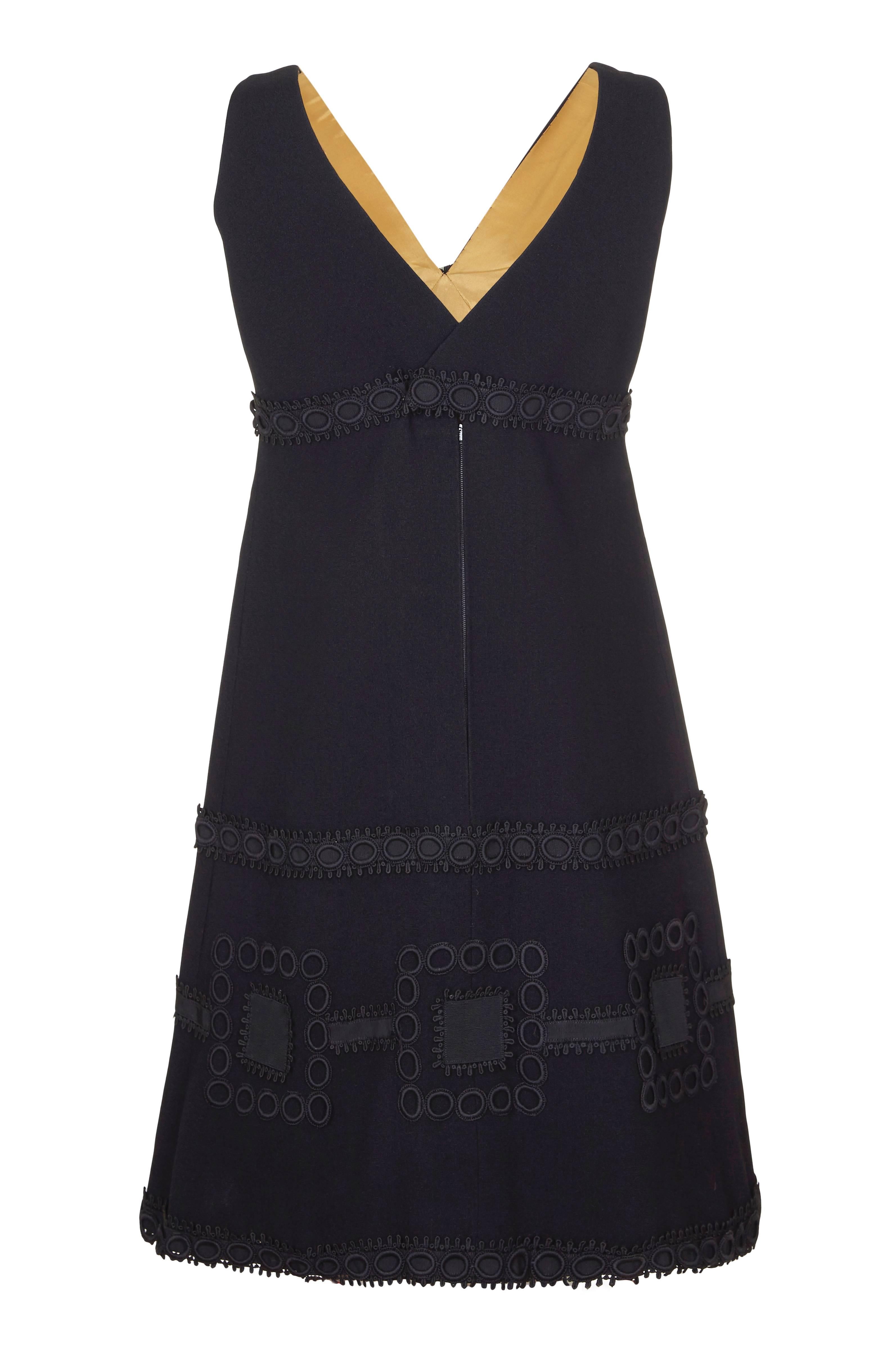 Cette magnifique mini robe noire des années 1960, de ligne empire, est une création couture de la designer française Simone Mirman et est d'une qualité exceptionnelle. La robe est composée de crêpe noir et doublée de façon impeccable en satin doré.