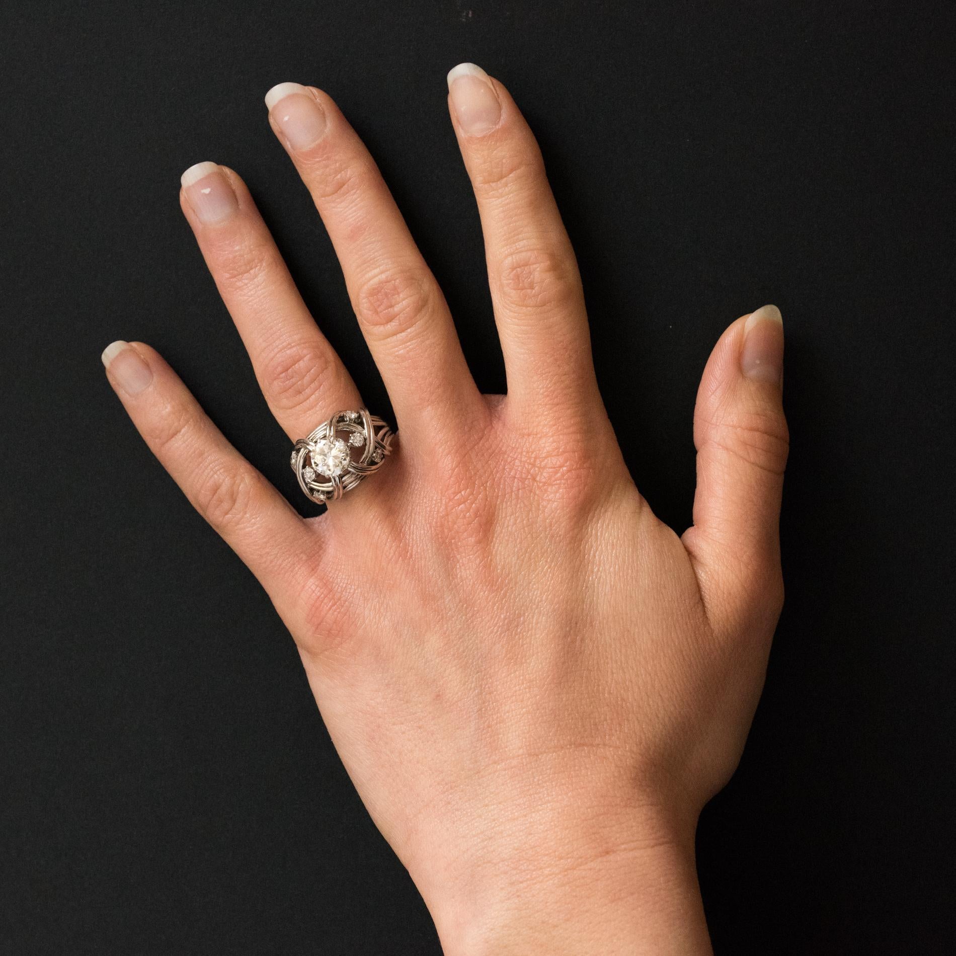 Ring in 18 karat white gold, eagle head hallmark. 
A splendid antique ring composed of interlaced golden strands. In the centre is a claw set modern brilliant cut diamond accentuated by 3 smaller brilliant cut diamonds on each side. 
Weight of the