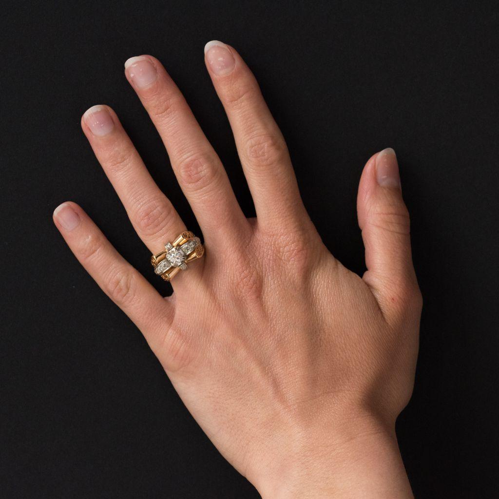 Ring in 18 carat yellow gold and platinium, eagle and dog heads hallmark. 
This magnificent ring from the 1960s has the volume of tank rings but is lighter due to the filigree openwork on the sides. The centrepiece of this tank ring features a large