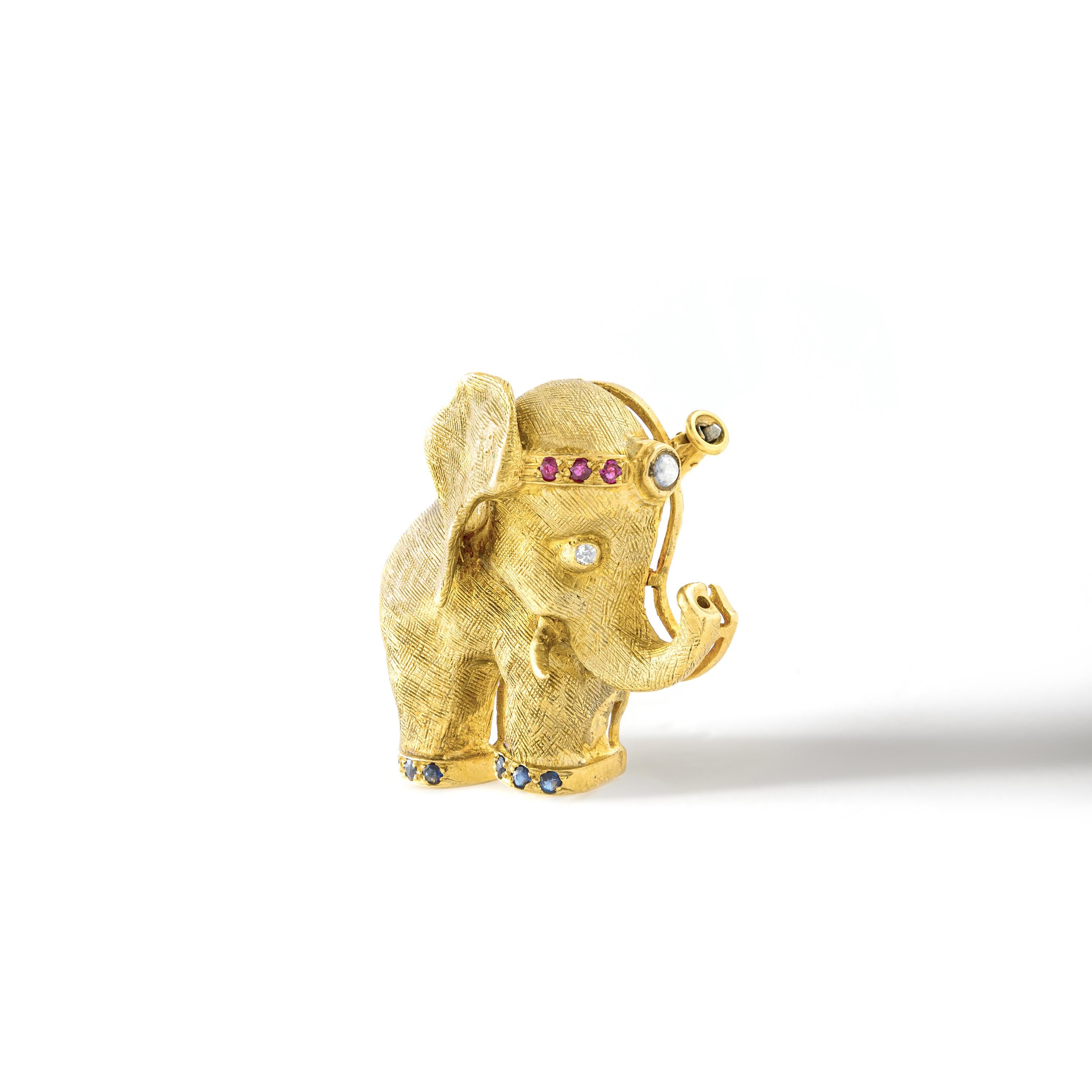 The exquisite 1960's French diamond ruby yellow gold 18K Elephant brooch clip. This stunning piece is not only a timeless fashion accessory, but it also carries powerful symbolism. The majestic elephant, rendered in luxurious yellow gold, is