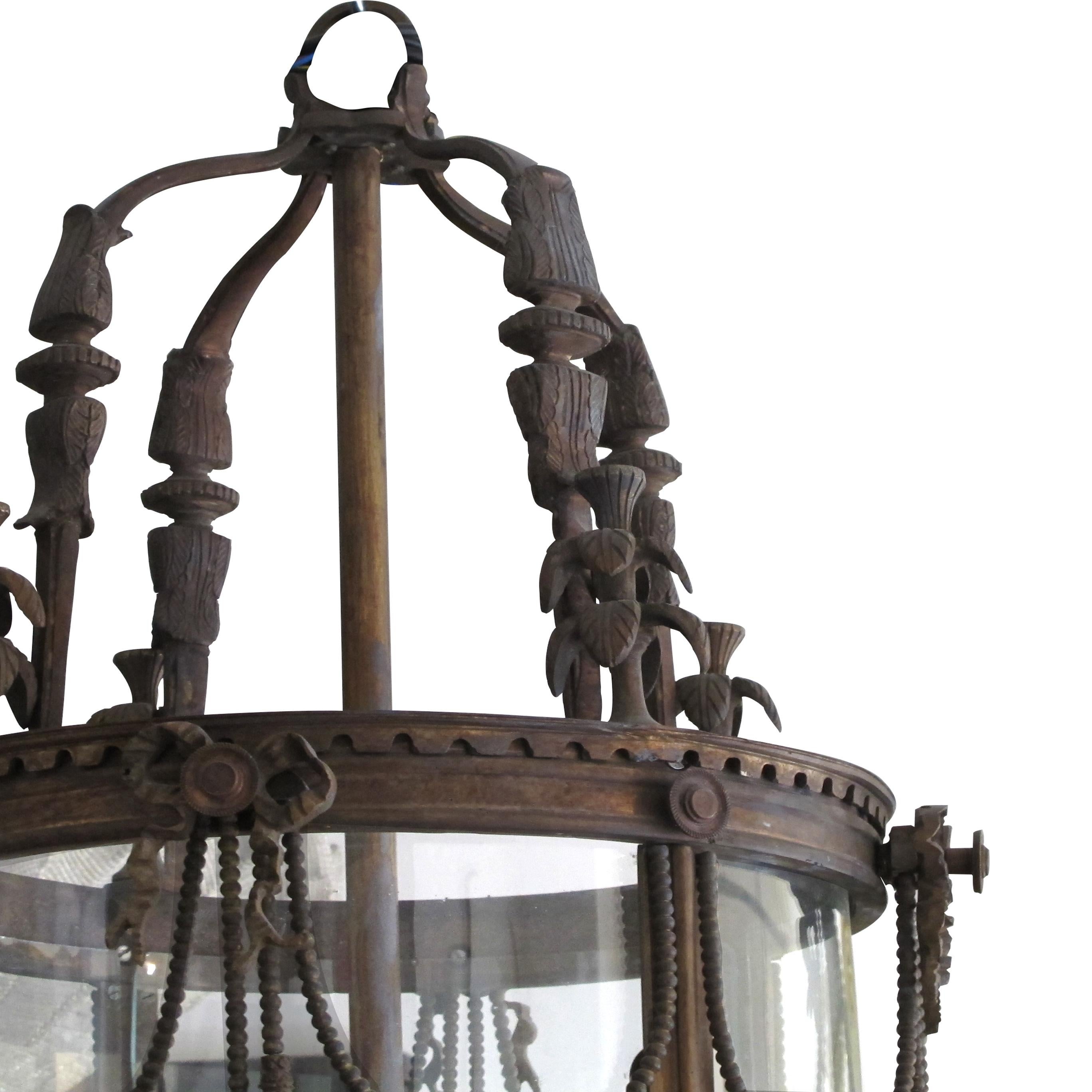 This very elegant 4-branch French lantern is from the 1960s in the style of Louis XVI and is crafted from bronze and features graceful and delicate ornaments such as garlands, ribbons, and swags. The lantern holds its original one-piece curved