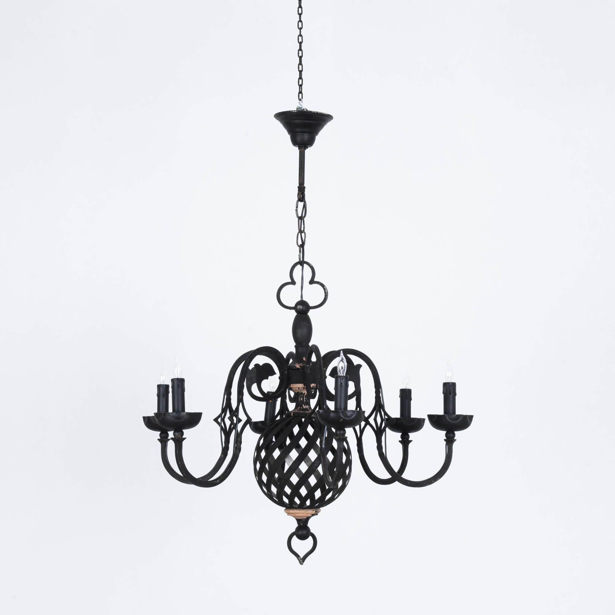 This chandelier from 1960s France is made of black metal. An elaborate design features six cascading arms which support candelabra bulbs. Beneath, an orb of undulating metal bars creates a hypnotic visual effect. An ornate and dramatic piece, fully