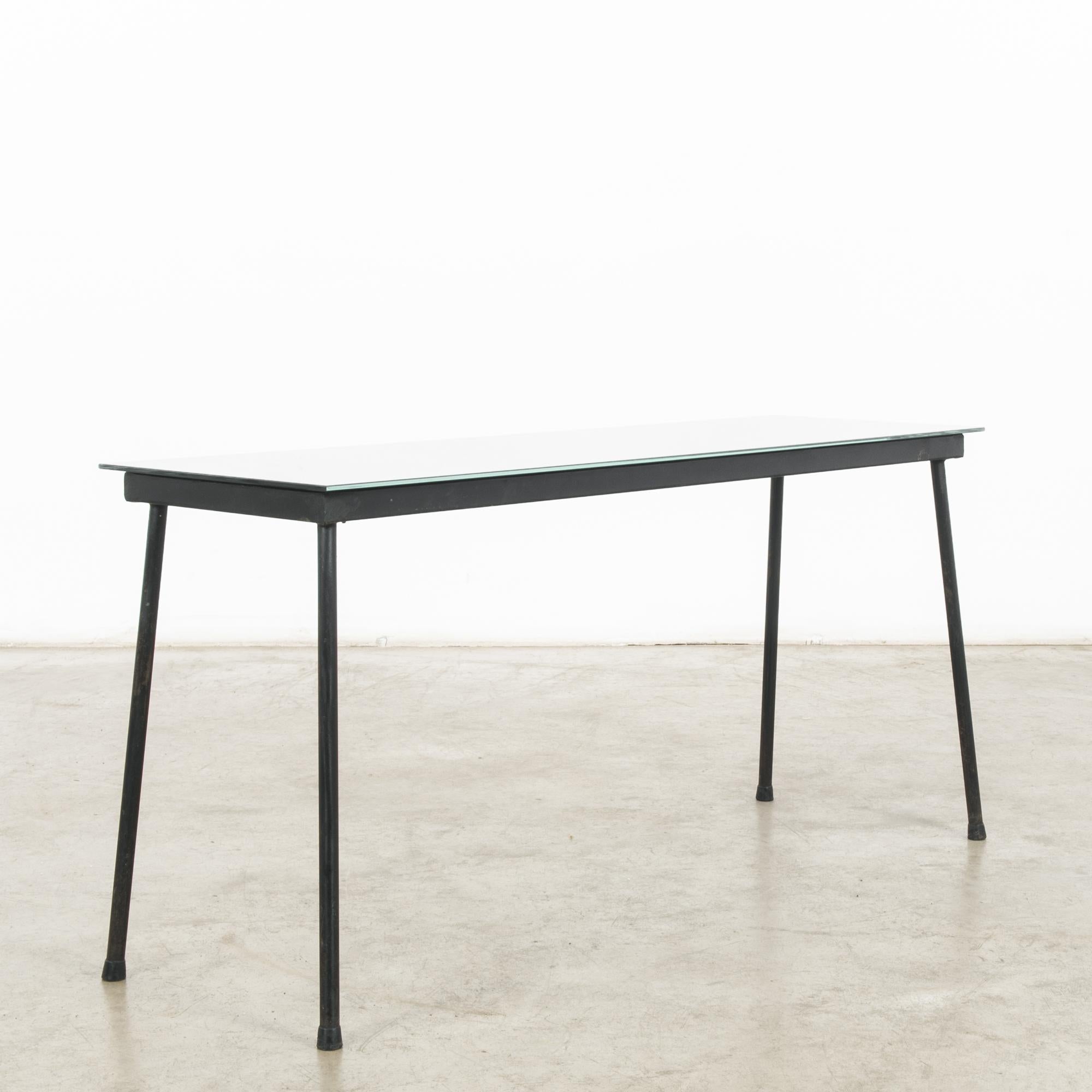 In the vibrant design landscape of 1960s France, this metal coffee table with a glass top epitomizes the sleek sophistication and modernist charm of the era. Crafted with meticulous attention to detail, this piece represents the epitome of French