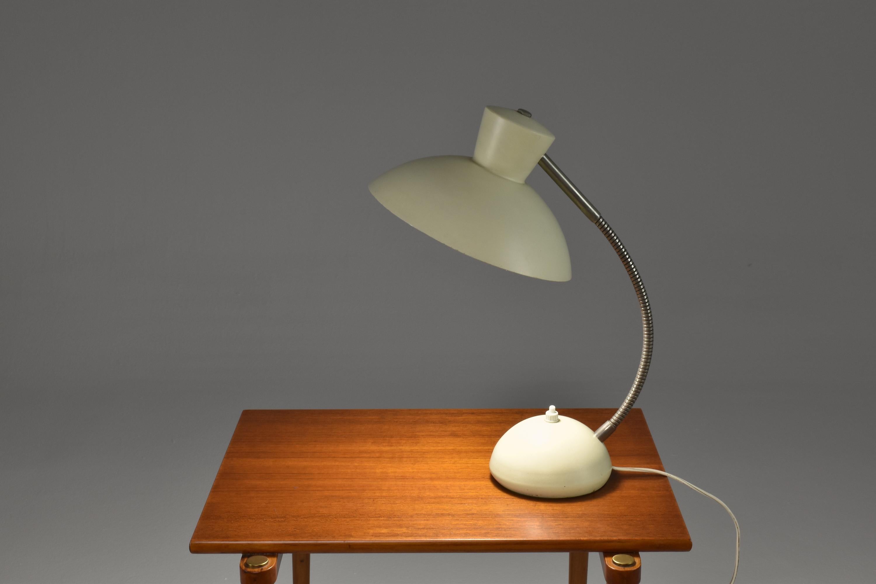 A fantastic mid-century vintage articulating desk light designed with a quality steel circular base and an aluminium shade in its original white lacquer. The base features a push-type switch and the arm is in steel. 
France. Circa 1960's. 

The