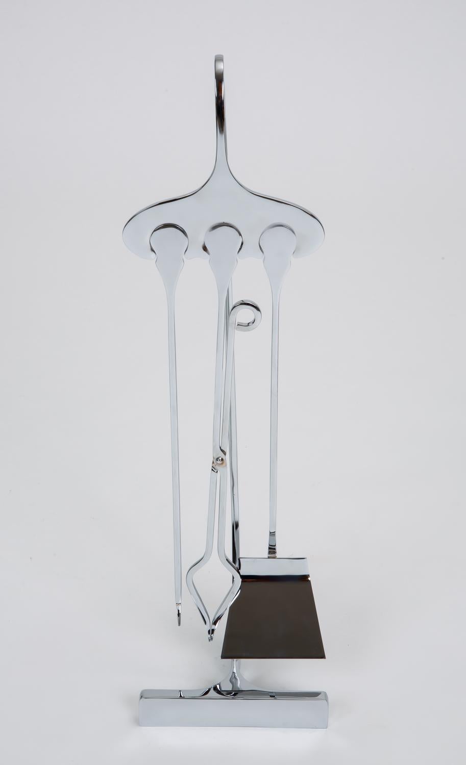 An inventive set of fireplace tools in the style of Jacques Charles’ curvilinear work for the French Ligne Inox. A chrome-plated stand holds a matching shovel, poker and tongue. The rounded handles of the accessories fit into complimentary notches