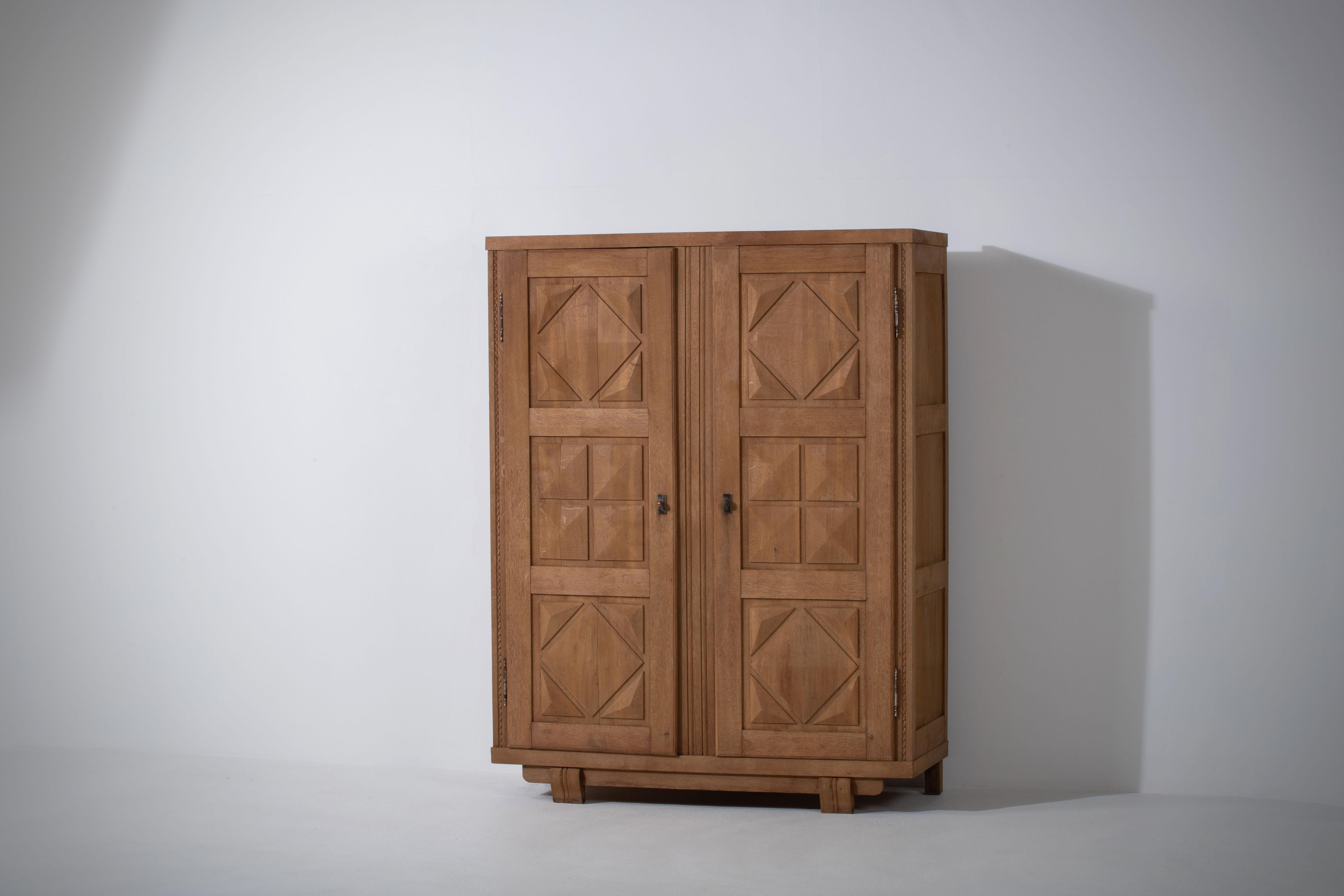Beautiful oak vintage wardrobe made in the 1960s. It has a double opening doors to shelve space with geometrical patterned doors. A great vintage piece in good condition which would bring a huge touch of style to any bedroom.