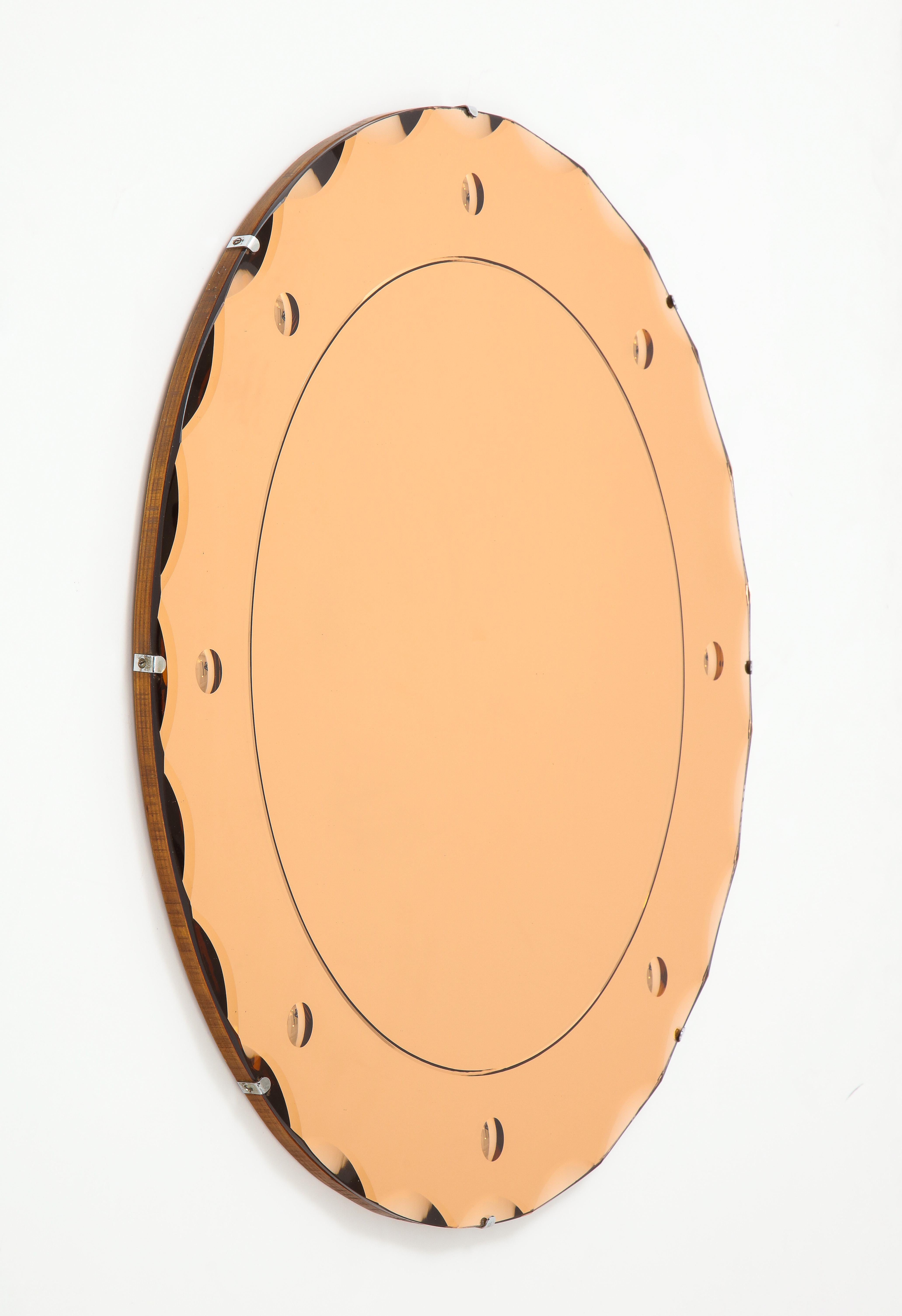 1960s modern peach colored French wall mirror, with wood back and chrome detail.