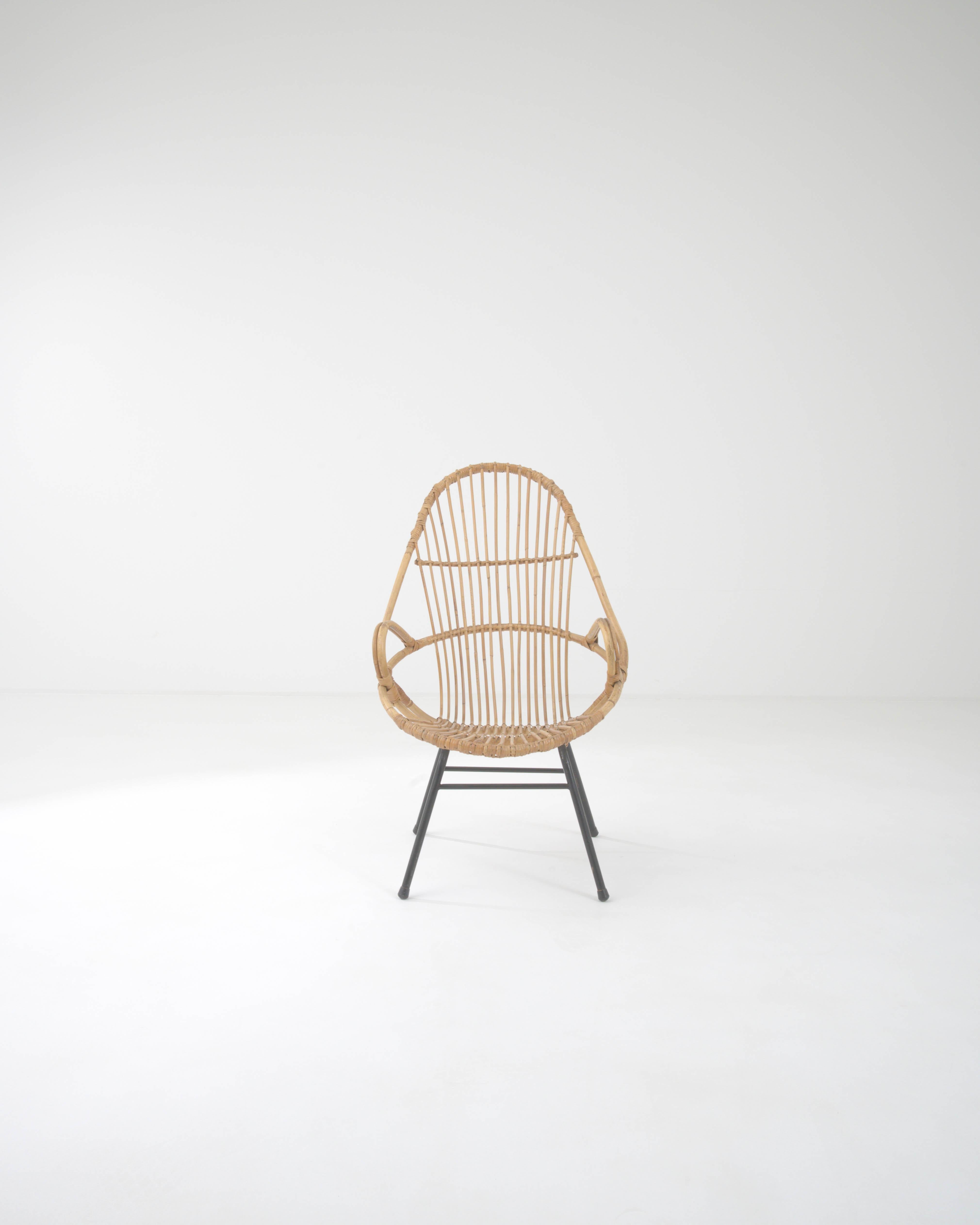 An occasional chair from France, circa 1960. This french-made armchair is a playful twist on a midcentury classic. Using lashed together rattan, artisans have crafted a chair both geometrically pleasing and surprisingly comfortable. Created by