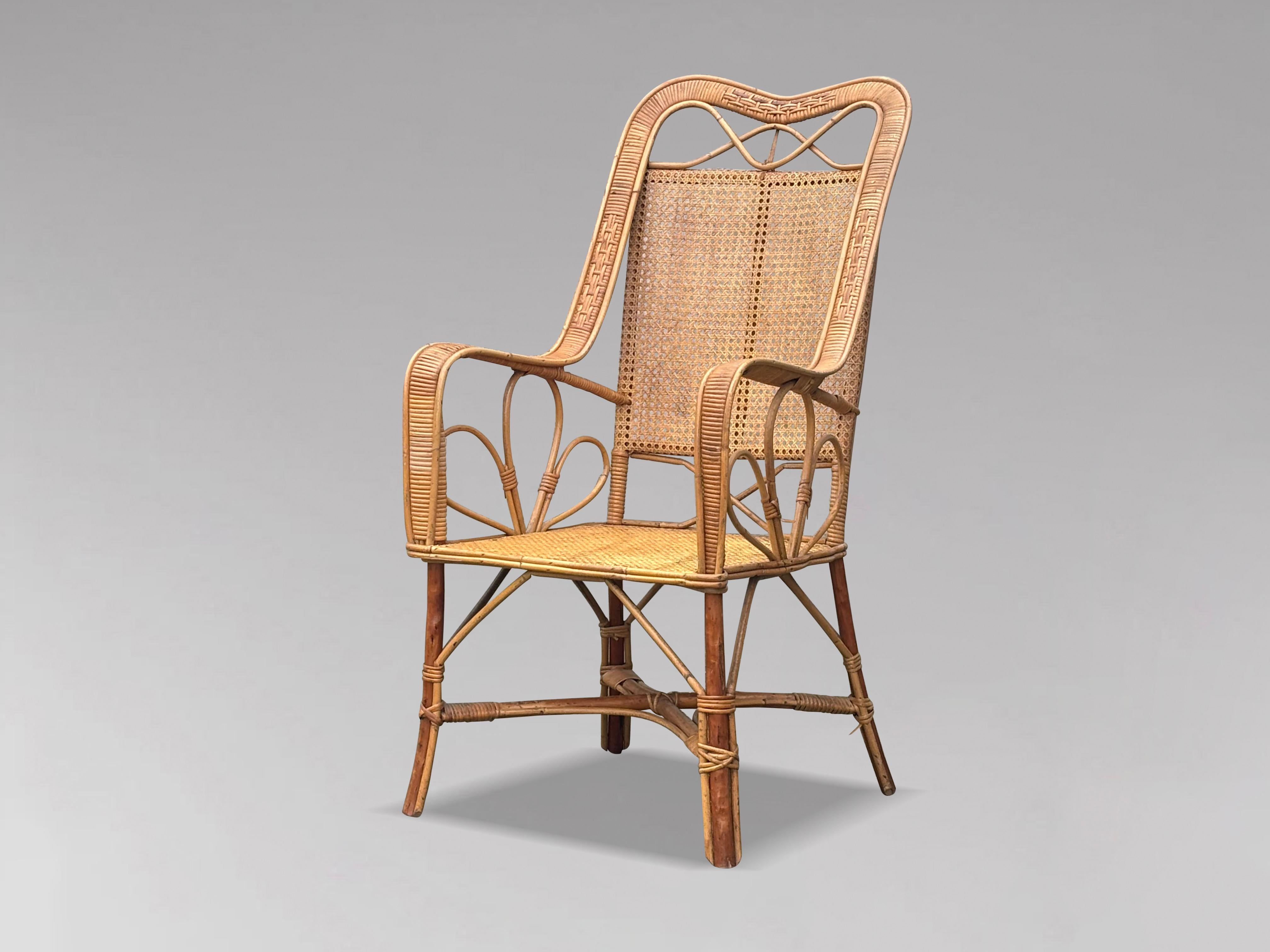 Sillón de bambú, caña y ratán de la Riviera francesa de mediados del siglo XX. Presenta una estructura de bambú con respaldo y brazos de ratán tejido a mano, y caña en el asiento y el respaldo. El diseño es muy elegante y tan cómodo como parece.