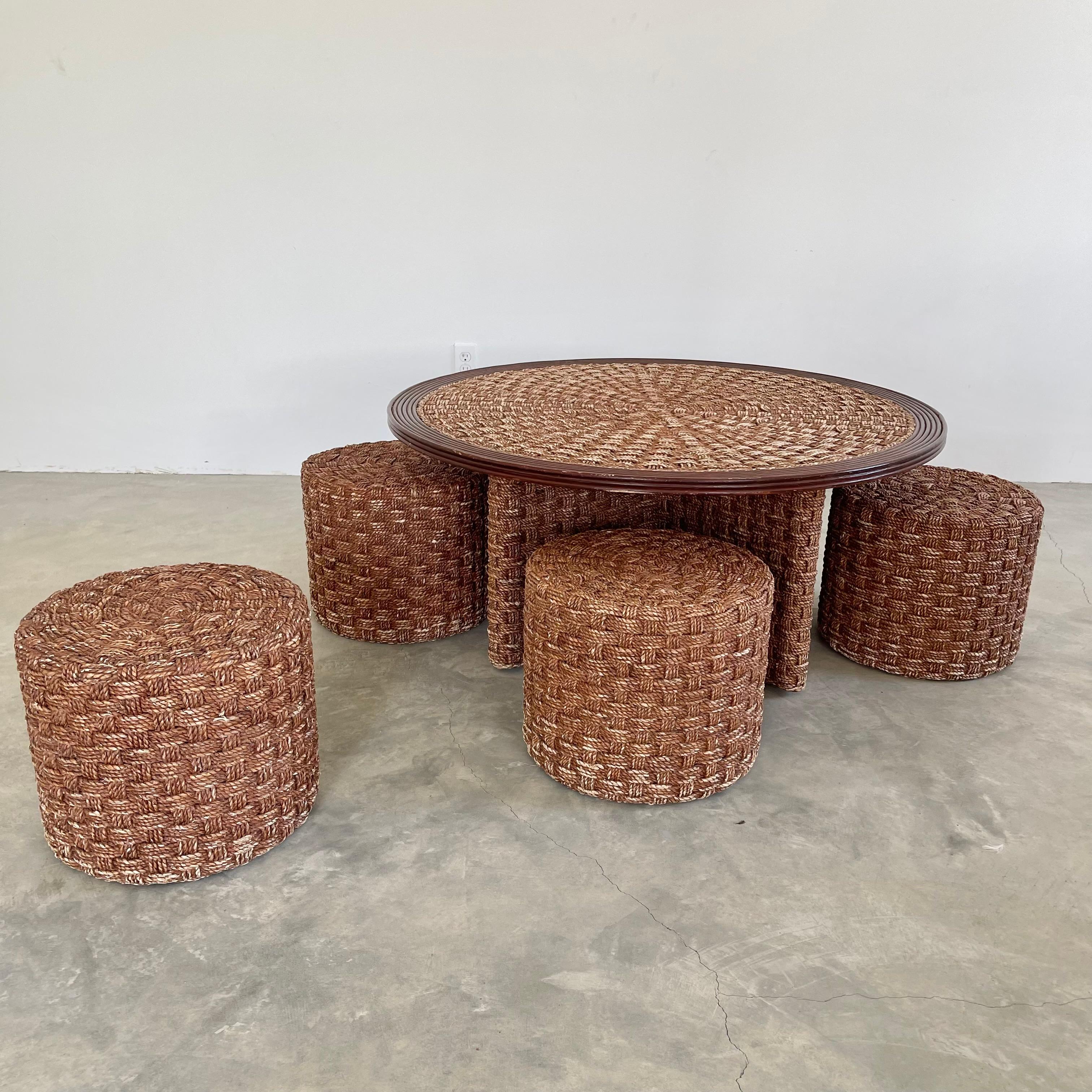 Unique rope and wood table with four matching rope stools. Perfect indoors or in a covered patio. Rope is woven flat in a criss cross pattern. Four stools tuck away neatly under table top and fit snug around the table base. Eye catching set, adding
