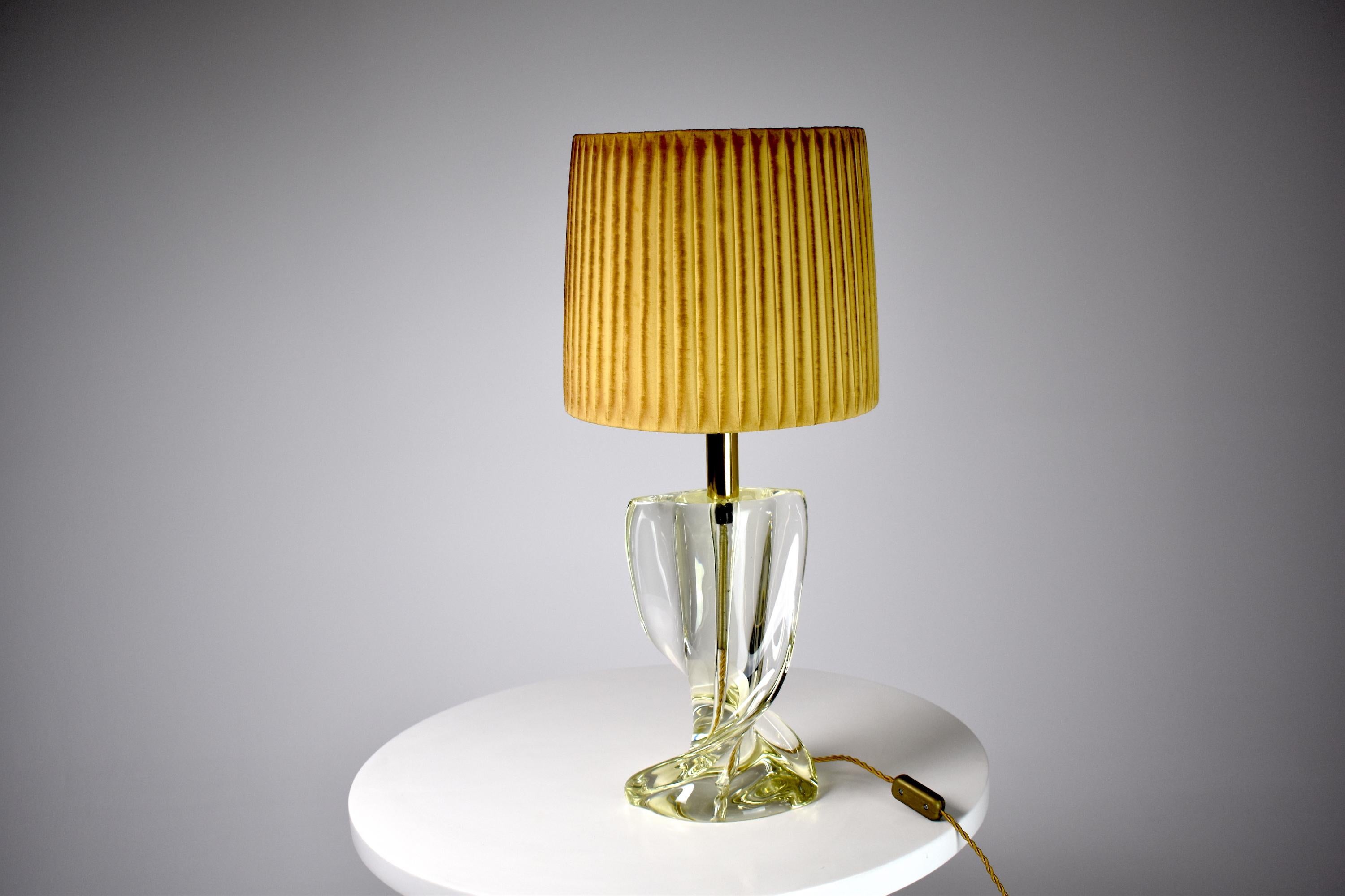A French 20th-century vintage statement table lamp from the 1960's period built out of sculptural crystal and in fully restored condition: new hand-tinted pleated fabric gold cylindrical shade, a polished brass stem, and new cable cold rewiring. Its