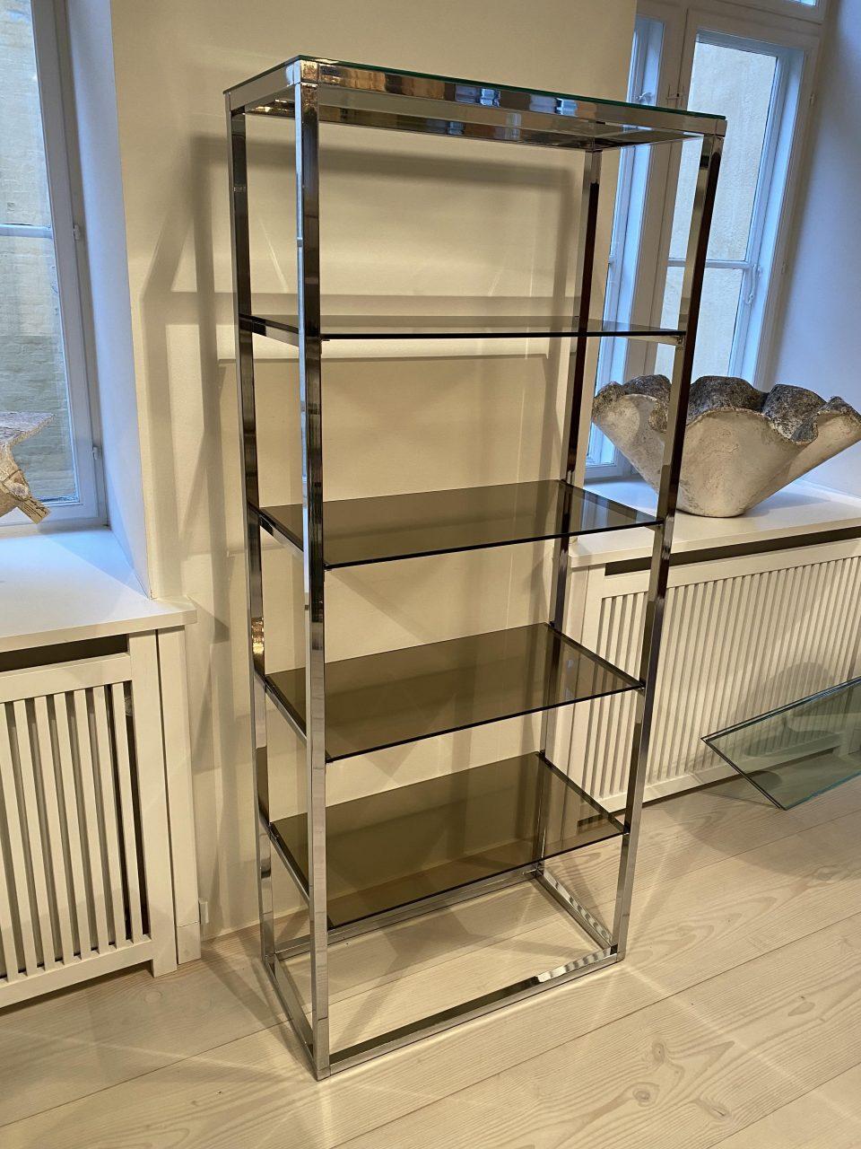 Tall and splendid chrome-plated metal shelf unit, from the late 1960s. Accompanying smoky glass shelves. The design is sleek and elegant, and this piece would look beautiful in a private home, as well as in a shop interior.

The shelving is