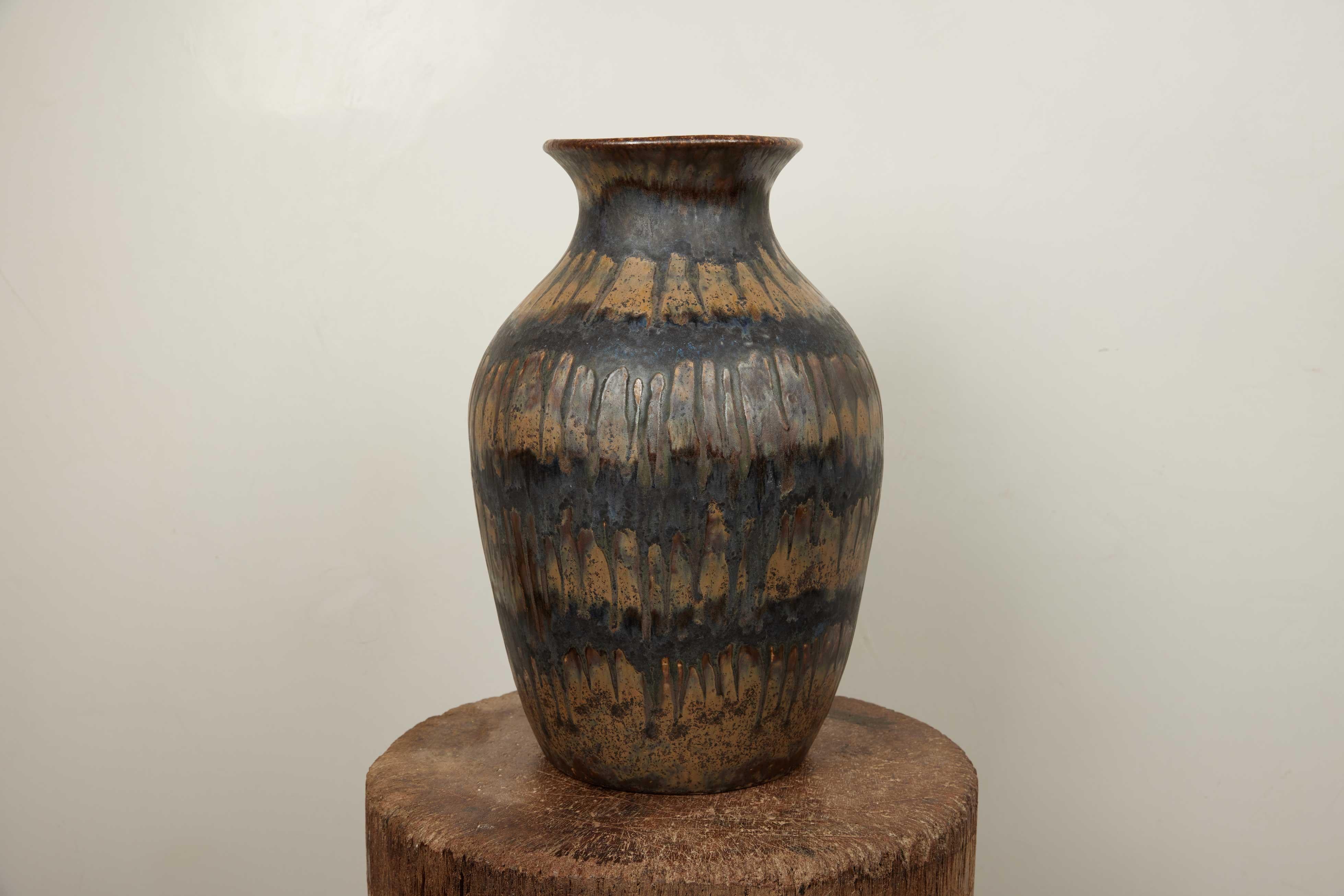 Vase en poterie de studio français des années 1960 

Ce captivant récipient en poterie d'atelier française des années 1960 incarne l'essence de l'art de la céramique du milieu du siècle. D'une hauteur de 17 pouces, d'une largeur de 11 pouces et