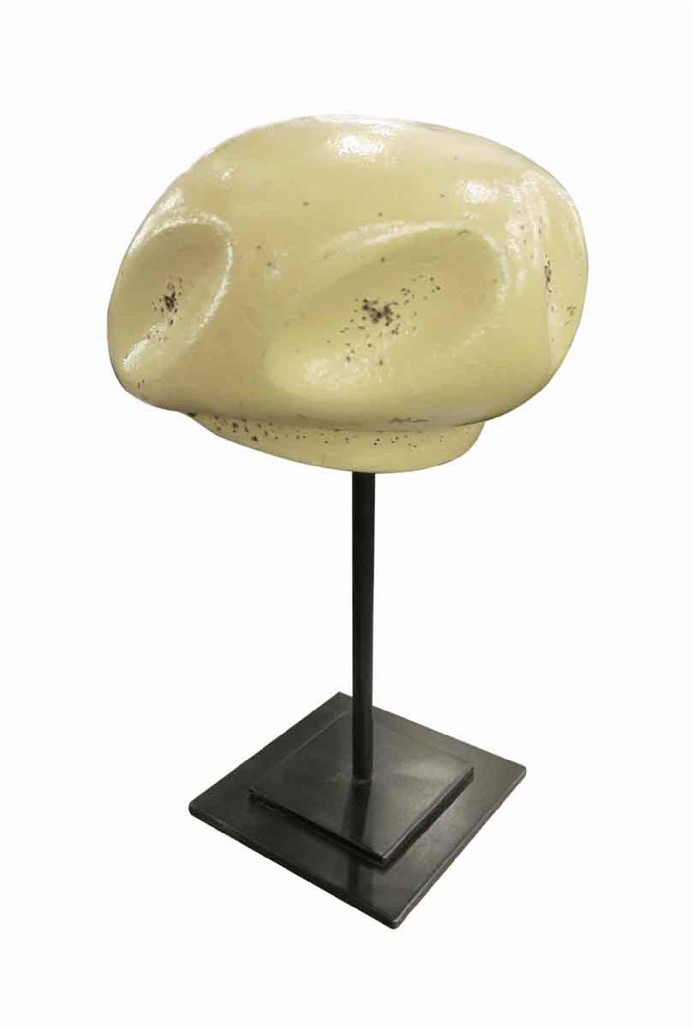 1960s tan hat mold on a black metal stand sculpture from France. This can be seen at our 2420 Broadway location on the upper west side in Manhattan.